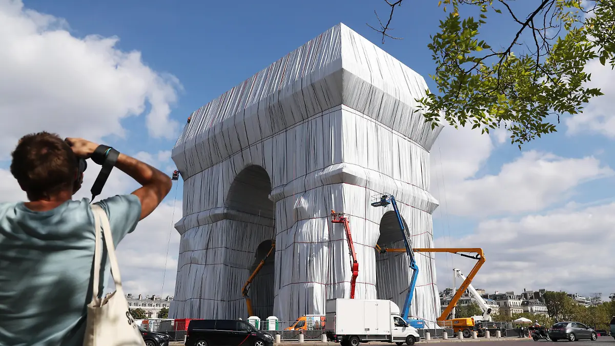 210916 -- PARIS, Sept. 16, 2021 -- A man takes photos of the wrapped Arc de Triomphe before an inauguration in Paris, France, on Sept. 16, 2021. The entire Arc de Triomphe at the top of the Champs-Elysees in Paris is to stay wrapped in fabric for two weeks, an art installation conceived by the late artist Christo and inaugurated on Thursday by French President Emmanuel Macron. The 50-meter high, 45-meter long and 22-meter wide monument built by Napoleon, is now wrapped head to toe in 25,000 square metres of recyclable silvery-blue fabric and 3,000 meters of red rope. FRANCE-PARIS-ARC DE TRIOMPHE-FABRIC-WRAPPING GaoxJing PUBLICATIONxNOTxINxCHN
