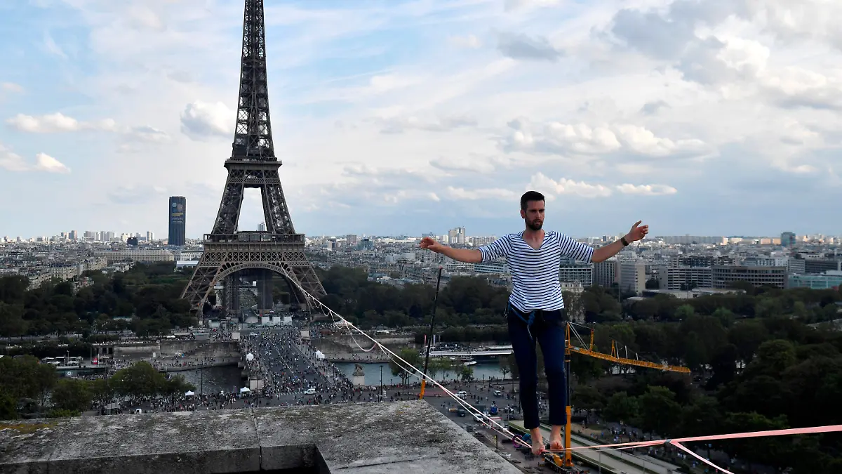 18.09.2021, Frankreich, Paris: Nathan Paulin, Akrobat aus Frankreich, kommt am Theatre National de Chaillot an, nachdem er auf einem Seil vom Eiffelturm über die Seine gelaufen ist. Das Kunstück ist Teil der Veranstaltungen in ganz Frankreich anlässlich der Tage des nationalen Kulturerbes. Foto: Alain Jocard/AFP POOL/AP/dpa +++ dpa-Bildfunk +++
