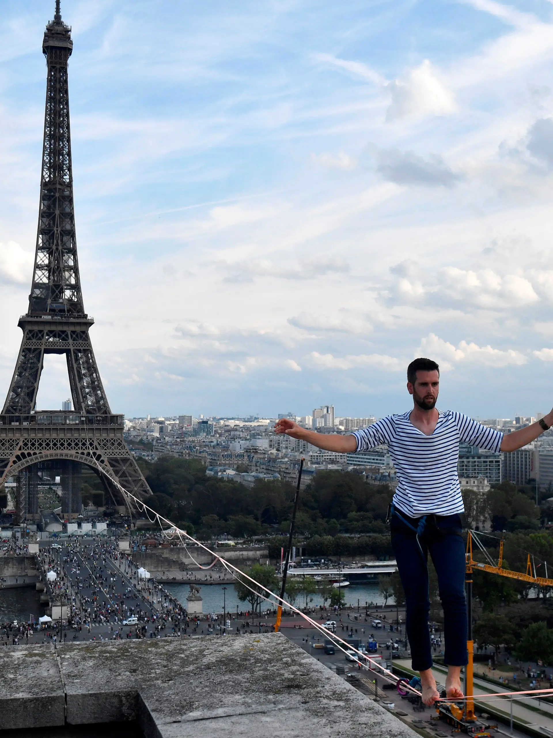 18.09.2021, Frankreich, Paris: Nathan Paulin, Akrobat aus Frankreich, kommt am Theatre National de Chaillot an, nachdem er auf einem Seil vom Eiffelturm über die Seine gelaufen ist. Das Kunstück ist Teil der Veranstaltungen in ganz Frankreich anlässlich der Tage des nationalen Kulturerbes. Foto: Alain Jocard/AFP POOL/AP/dpa +++ dpa-Bildfunk +++
