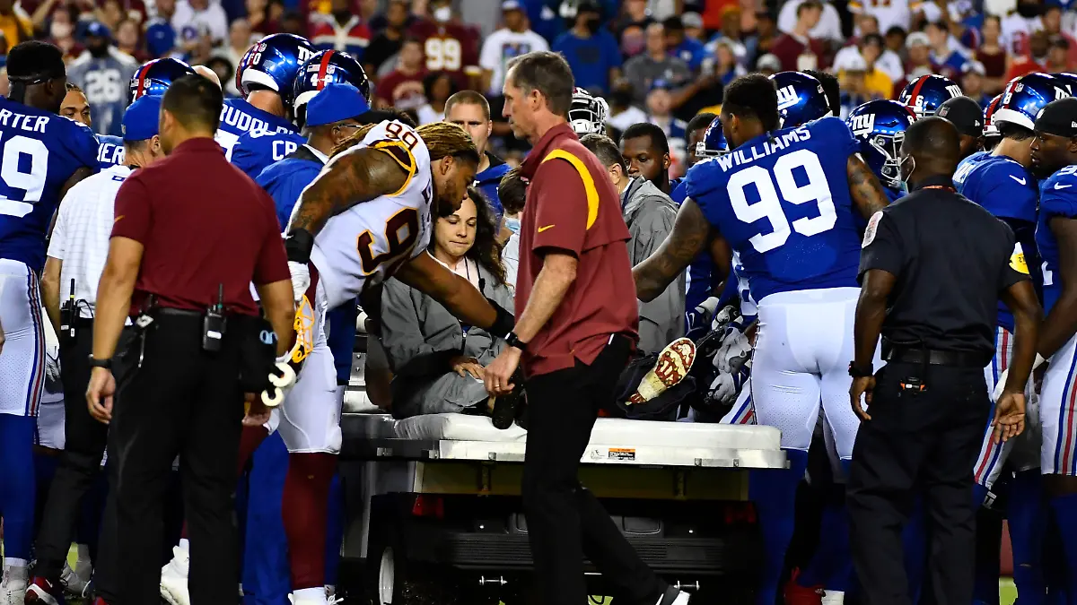 Sep 16, 2021; Landover, Maryland, USA; New York Giants center Nick Gates (65) is consoled by Washington Football Team defensive end Chase Young (99) and New York defensive end Leonard Williams (99) during the first half at FedExField. Mandatory Credit: Brad Mills-USA TODAY Sports