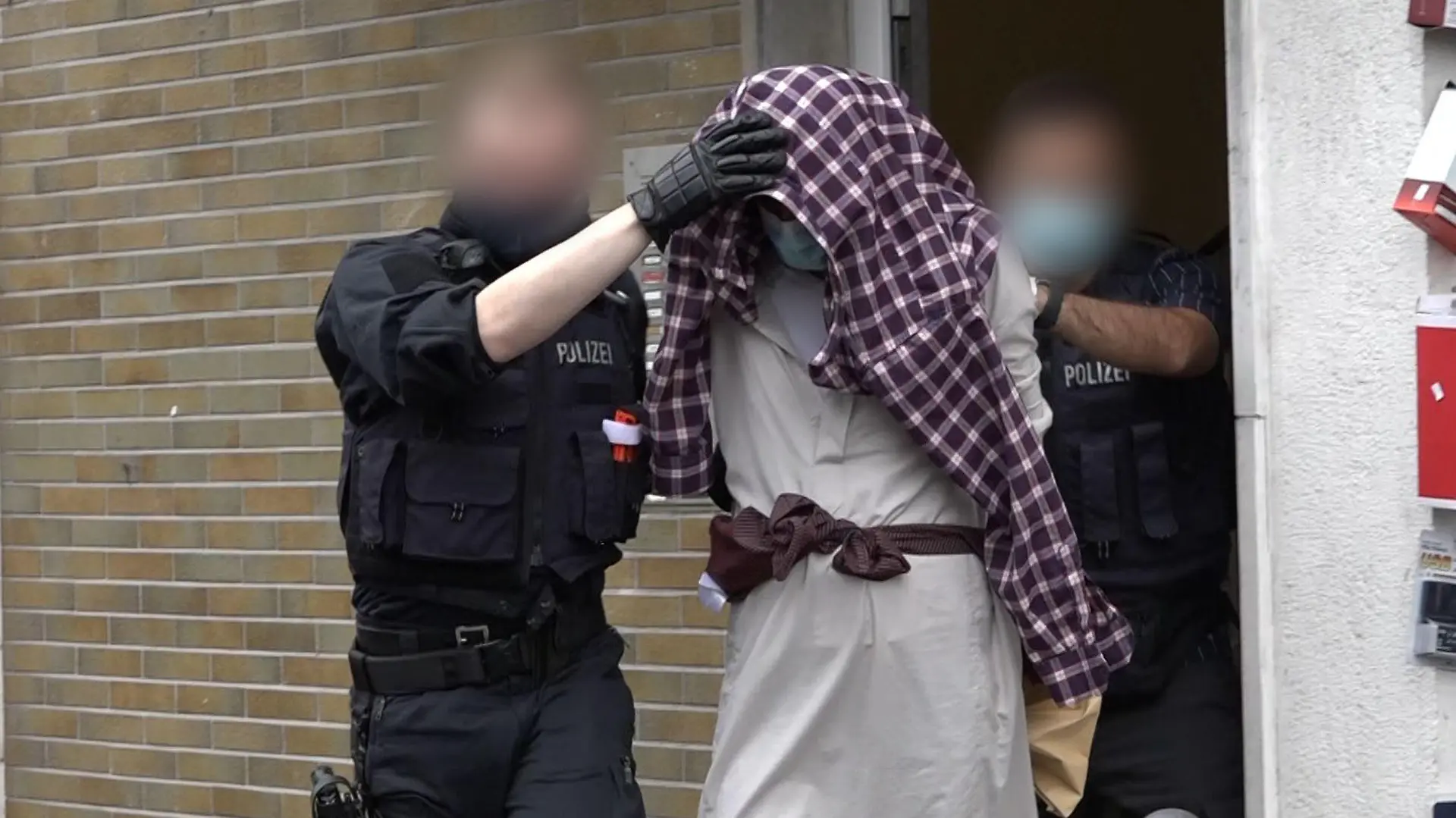 dpatopbilder - 16.09.2021, Nordrhein-Westfalen, Hagen: Ein Mann wird im Zusammenhang mit dem mutmaßlich geplanten Anschlag auf die Hagener Synagoge von Polizisten abgeführt. Nach dem Polizeieinsatz an der Synagoge in Hagen hat die Polizei vier Verdächtige festgenommen, darunter einen 16-Jährigen in Hagen. Das teilte die Hagener Polizei am Donnerstag mit. Parallel liefen Durchsuchungen, um mögliche Beweismittel zu sichern, sagte ein Sprecherin. Foto: Alex Talash/dpa - ACHTUNG: Personen wurden aus rechtlichen Gründen gepixelt +++ dpa-Bildfunk +++