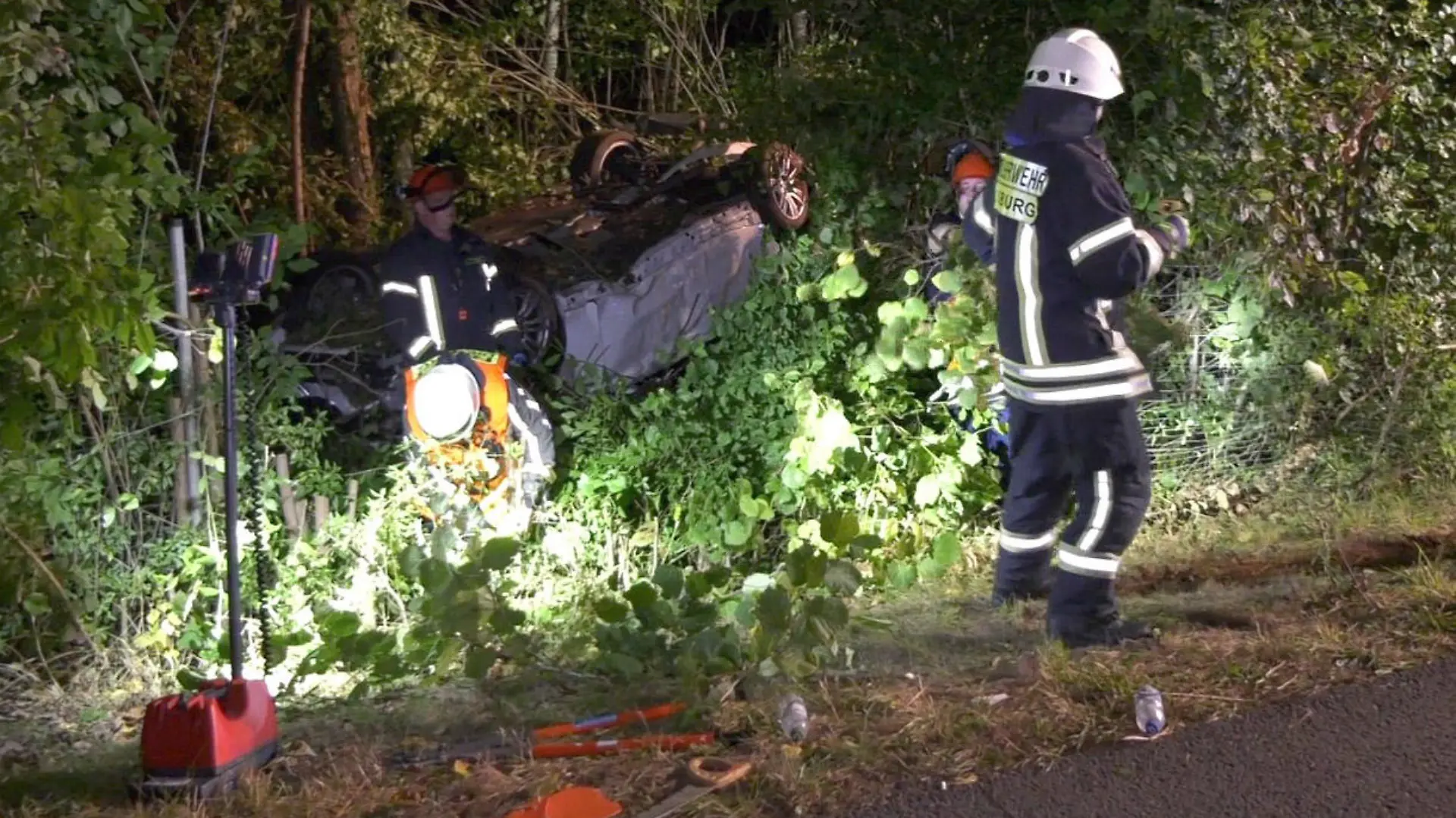 17.09.2021, Hessen, Groß-Zimmern: Feuerwehrleute arbeiten an einem Auto abseits der Straße. Auf der Bundesstraße 26 bei Groß-Zimmern (Kreis Darmstadt-Dieburg) hat sich am Donnerstagabend ein 18 Jahre alter Autofahrer mit seinem Wagen überschlagen. Dabei seien der Fahrer und seine vier Mitfahrer im Alter zwischen 18 und 20 Jahren verletzt worden, teilte die Polizei am Freitag mit. Foto: -/KEUTZ TV-NEWS/dpa +++ dpa-Bildfunk +++