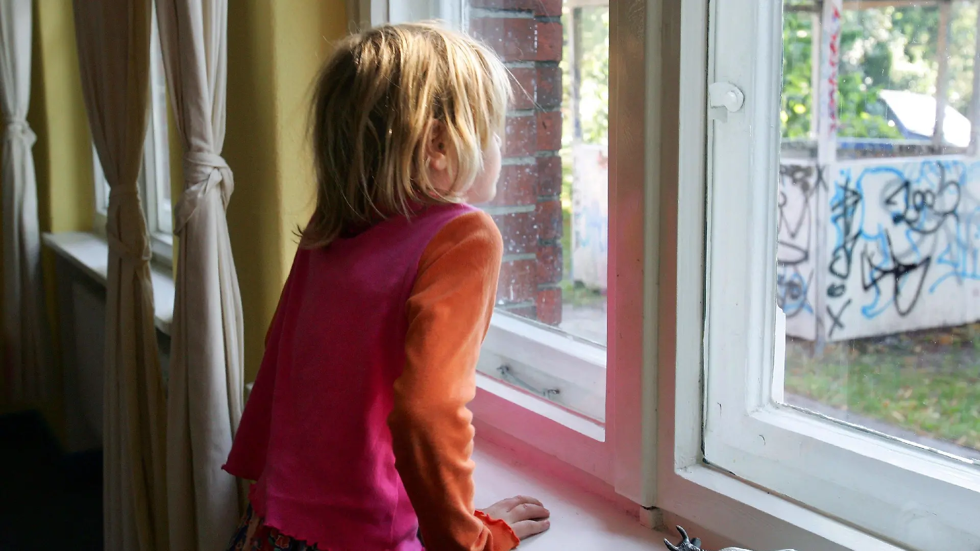 ARCHIV - Ein kleines Mädchen schaut aus einem Fenster der Kinderstiftung "Jona's Haus" in Berlin (Archivfoto vom 16.09.2006, Illustration zum Thema Kinderarmut). In Deutschland driften Arm und Reich immer weiter auseinander. Die Ungleichheit bei den Einkommen und die Armut - gerade auch von Kindern - haben hierzulande in den vergangenen Jahren nach einer OECD-Studie stärker zugenommen als in anderen Ländern. 2005 lebten demnach unterhalb der Armutsschwelle 10,5 bis 11 Prozent der Bevölkerung. Foto: Gero Breloer (zu dpa 4197 vom 21.10.2008) +++(c) dpa - Bildfunk+++