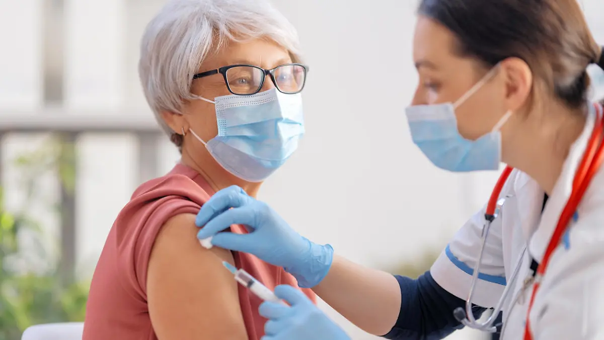 Doctor vaccinating a senior woman. Virus protection. COVID-2019.