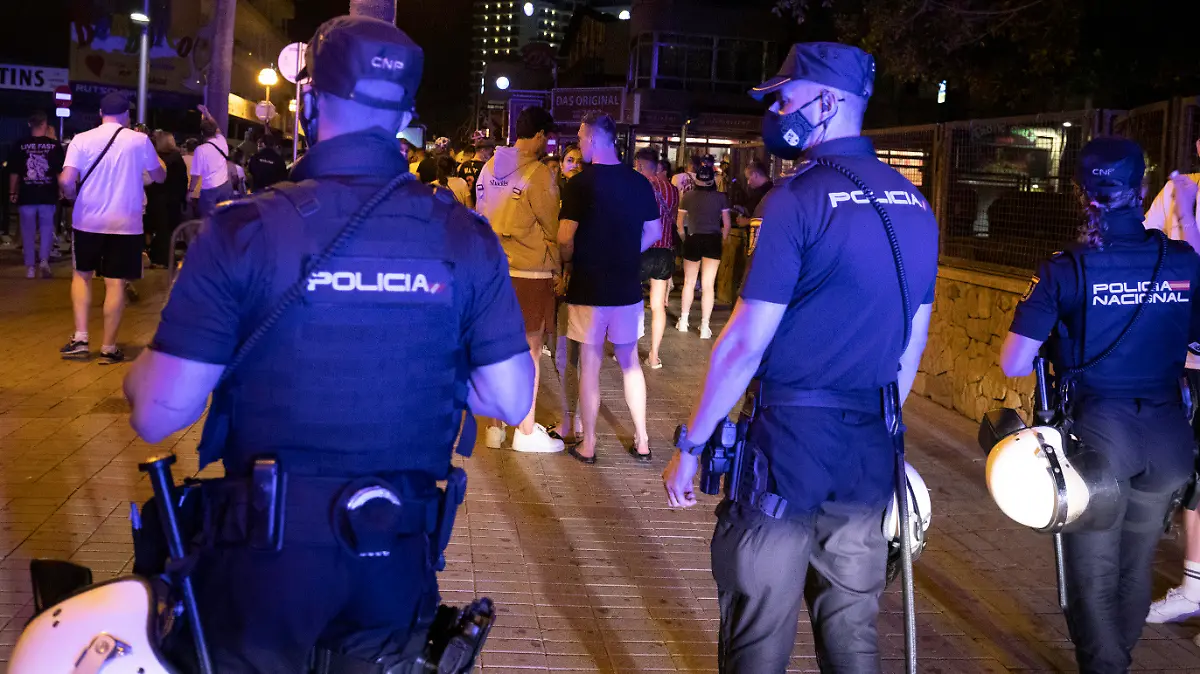 ARCHIV - 06.06.2021, Spanien, Palma: Die Polizei fordert Menschen, die am Strand von Arenal trinken, zum Gehen auf. Angesichts stark steigender Corona-Zahlen werden auf der beliebten Urlaubsinsel Mallorca voraussichtlich wieder schärfere Einschränkungen ergriffen. (zu dpa «Mallorca tritt wegen hoher Corona-Zahlen auf die Party-Bremse») Foto: Clara Margais/dpa +++ dpa-Bildfunk +++