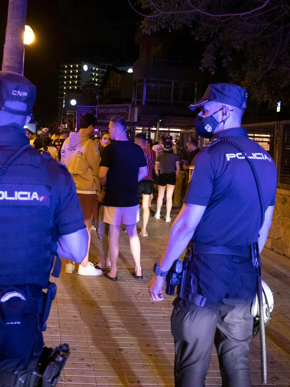 ARCHIV - 06.06.2021, Spanien, Palma: Die Polizei fordert Menschen, die am Strand von Arenal trinken, zum Gehen auf. Angesichts stark steigender Corona-Zahlen werden auf der beliebten Urlaubsinsel Mallorca voraussichtlich wieder schärfere Einschränkungen ergriffen. (zu dpa «Mallorca tritt wegen hoher Corona-Zahlen auf die Party-Bremse») Foto: Clara Margais/dpa +++ dpa-Bildfunk +++