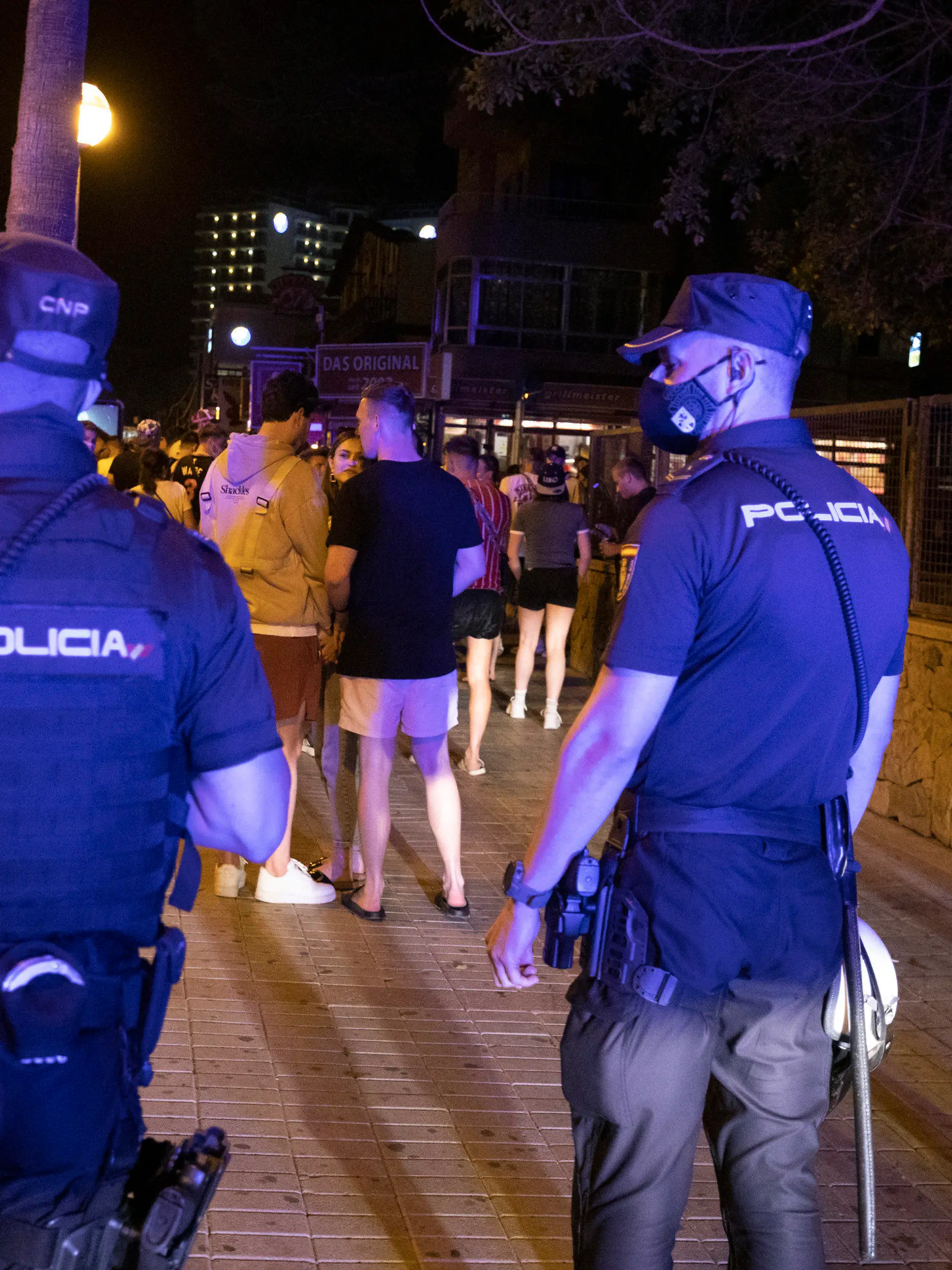 ARCHIV - 06.06.2021, Spanien, Palma: Die Polizei fordert Menschen, die am Strand von Arenal trinken, zum Gehen auf. Angesichts stark steigender Corona-Zahlen werden auf der beliebten Urlaubsinsel Mallorca voraussichtlich wieder schärfere Einschränkungen ergriffen. (zu dpa «Mallorca tritt wegen hoher Corona-Zahlen auf die Party-Bremse») Foto: Clara Margais/dpa +++ dpa-Bildfunk +++