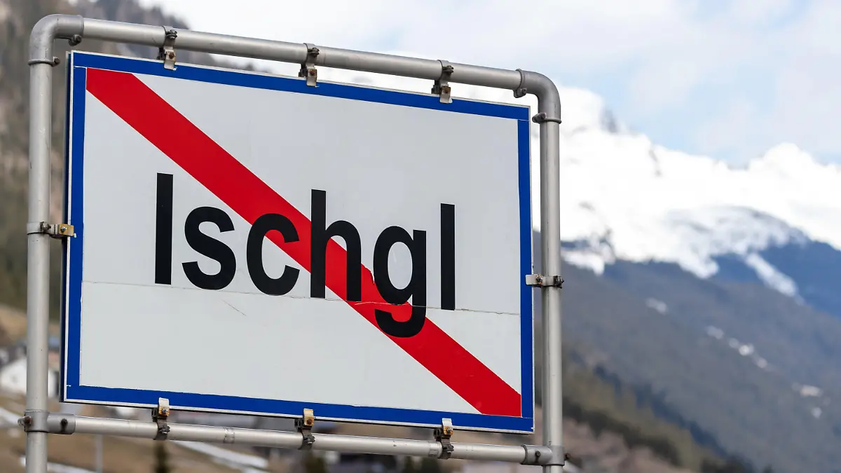 ARCHIV - 13.03.2020, Österreich, Ischgl: Ein Ortsschild mit durchgezogener roter Linie steht am Ende der Ortschaft Ischgl und zeigt an, das die Ortschaft an der Stelle endet. Viele Menschen zusammen an einem Ort und massenhaft Infektionen mit dem Coronavirus: Trotz dieser Gemeinsamkeit halten Experten einen Vergleich des Corona-Ausbruchs im Tönnis-Schlachbetrieb in Gütersloh und dem Geschehen im Tiroler Wintersportort Ischgl Anfang März für nicht haltbar. (zu dpa «Gütersloh und Ischgl - ein schwieriger Vergleich») Foto: Jakob Gruber/APA/dpa +++ dpa-Bildfunk +++