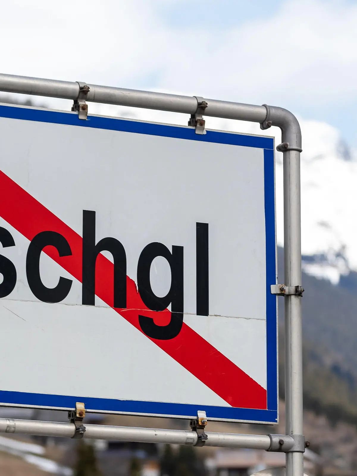 ARCHIV - 13.03.2020, Österreich, Ischgl: Ein Ortsschild mit durchgezogener roter Linie steht am Ende der Ortschaft Ischgl und zeigt an, das die Ortschaft an der Stelle endet. Viele Menschen zusammen an einem Ort und massenhaft Infektionen mit dem Coronavirus: Trotz dieser Gemeinsamkeit halten Experten einen Vergleich des Corona-Ausbruchs im Tönnis-Schlachbetrieb in Gütersloh und dem Geschehen im Tiroler Wintersportort Ischgl Anfang März für nicht haltbar. (zu dpa «Gütersloh und Ischgl - ein schwieriger Vergleich») Foto: Jakob Gruber/APA/dpa +++ dpa-Bildfunk +++
