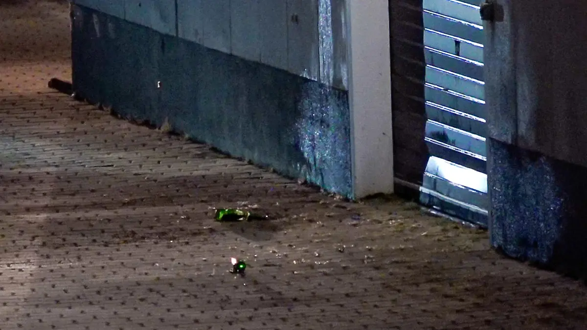 Glassplitter liegen auf dem Pflaster am Impfzentrum in Eich. Im sächsischen Vogtlandkreis hat es einen Brandanschlag auf ein Impfzentrum gegeben. Drei Unbekannte sollen am Dienstagabend Bierflaschen mit einer brennbaren Flüssigkeit auf das Gebäude in Treuen geworfen haben, wie die Polizei am Mittwochmorgen mitteilte.