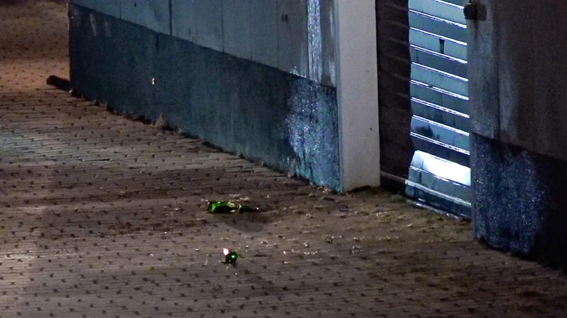 Glassplitter liegen auf dem Pflaster am Impfzentrum in Eich. Im sächsischen Vogtlandkreis hat es einen Brandanschlag auf ein Impfzentrum gegeben. Drei Unbekannte sollen am Dienstagabend Bierflaschen mit einer brennbaren Flüssigkeit auf das Gebäude in Treuen geworfen haben, wie die Polizei am Mittwochmorgen mitteilte.