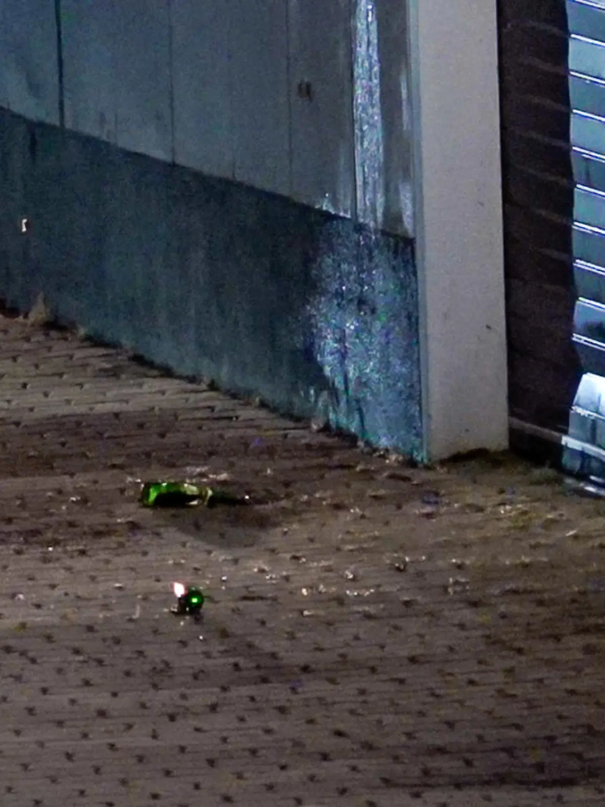 Glassplitter liegen auf dem Pflaster am Impfzentrum in Eich. Im sächsischen Vogtlandkreis hat es einen Brandanschlag auf ein Impfzentrum gegeben. Drei Unbekannte sollen am Dienstagabend Bierflaschen mit einer brennbaren Flüssigkeit auf das Gebäude in Treuen geworfen haben, wie die Polizei am Mittwochmorgen mitteilte.