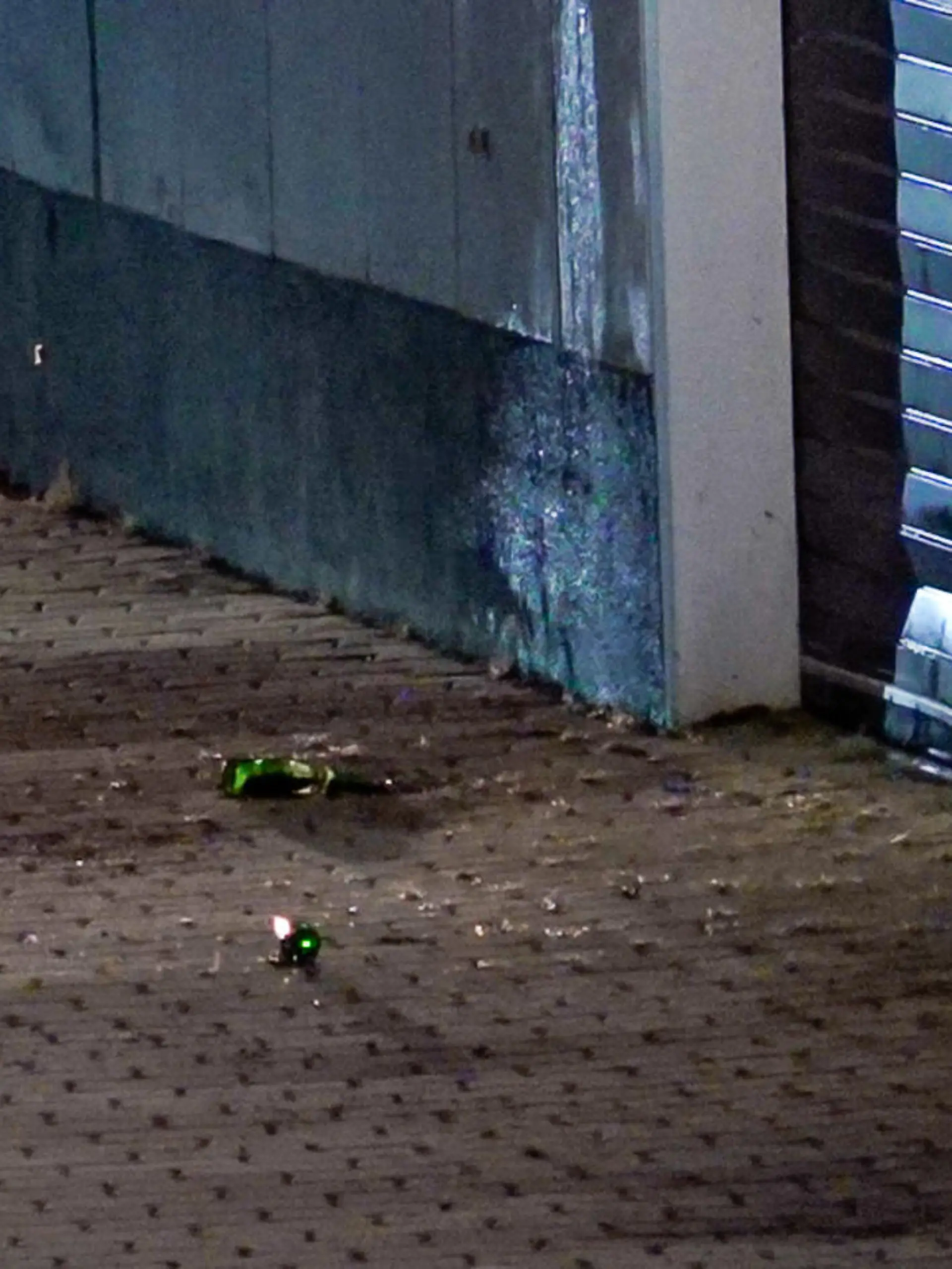 Glassplitter liegen auf dem Pflaster am Impfzentrum in Eich. Im sächsischen Vogtlandkreis hat es einen Brandanschlag auf ein Impfzentrum gegeben. Drei Unbekannte sollen am Dienstagabend Bierflaschen mit einer brennbaren Flüssigkeit auf das Gebäude in Treuen geworfen haben, wie die Polizei am Mittwochmorgen mitteilte.