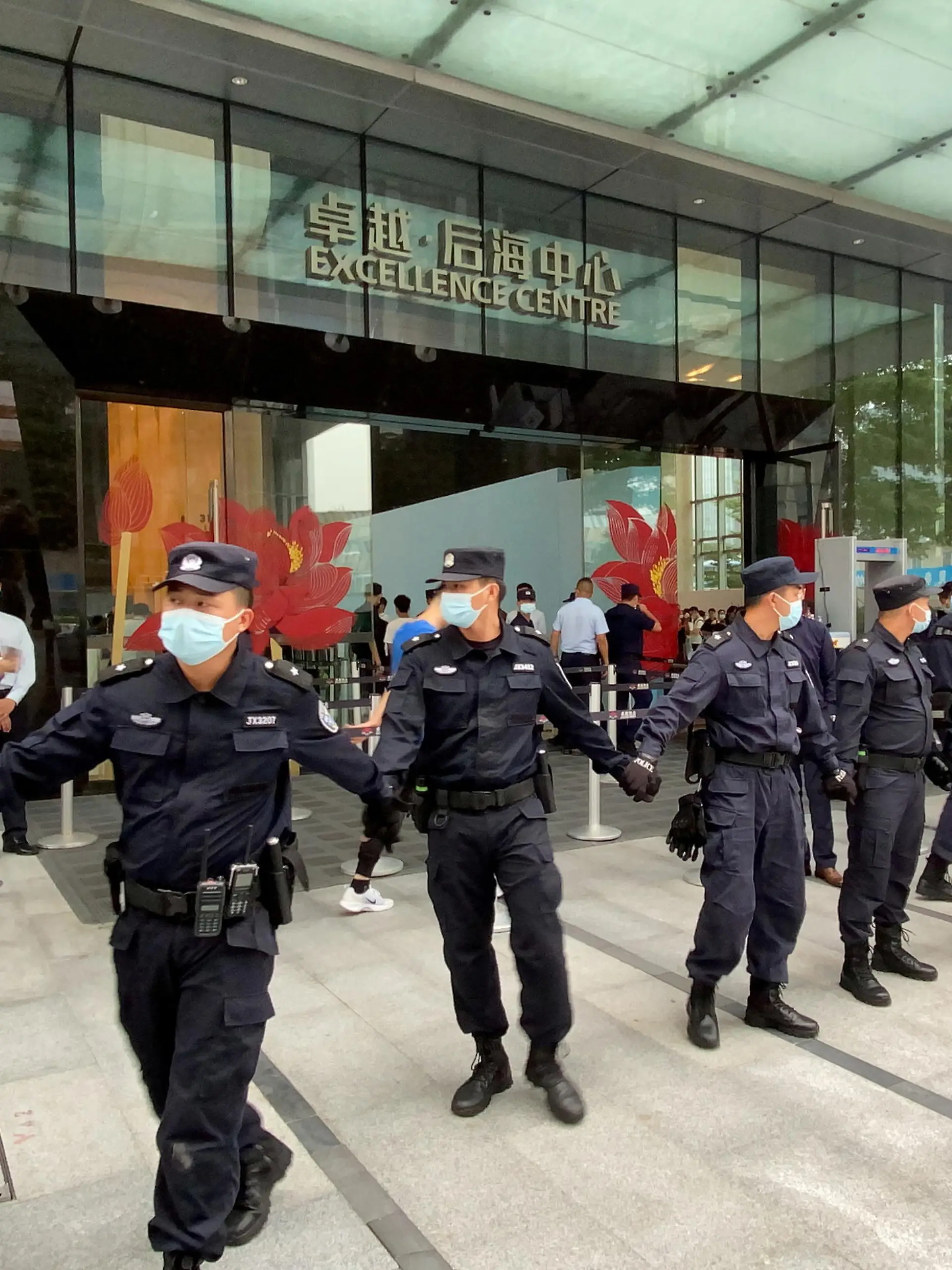 FILE PHOTO: Security personnel form a human chain as they guard outside the Evergrande's headquarters, where people gathered to demand repayment of loans and financial products, in Shenzhen, Guangdong province, China September 13, 2021. REUTERS/David Kirton/File Photo