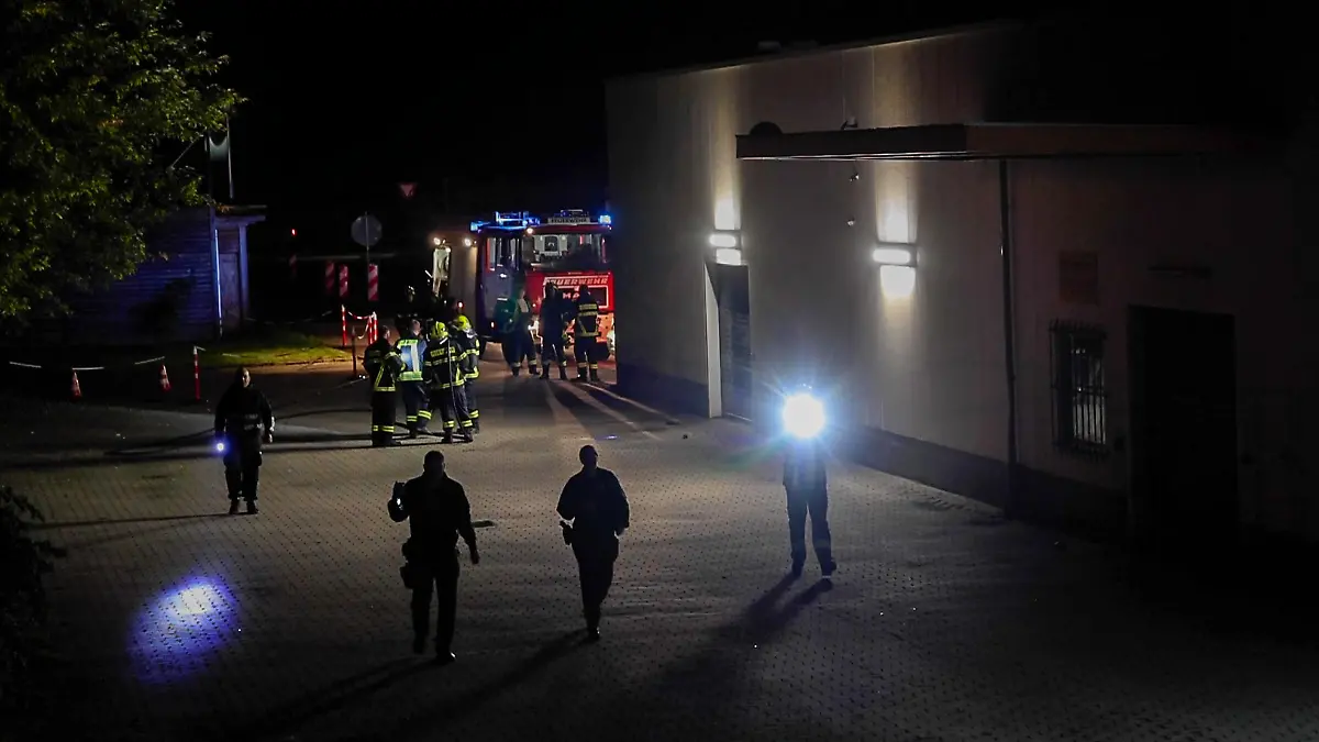 Mit Taschenlampen such Polizeibeamte das Areal um das Impfzentrum in Eich nach Spuren ab. Im sächsischen Vogtlandkreis hat es einen Brandanschlag auf ein Impfzentrum gegeben. Drei Unbekannte sollen am Dienstagabend Bierflaschen mit einer brennbaren Flüssigkeit auf das Gebäude in Treuen geworfen haben, wie die Polizei am Mittwochmorgen mitteilte.