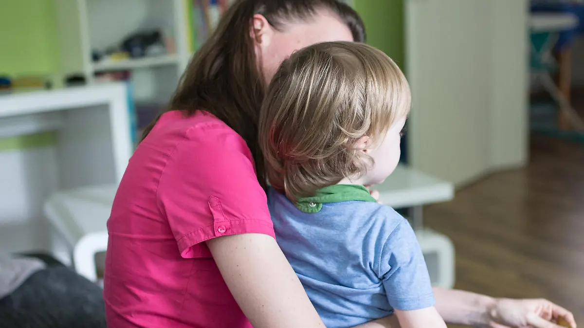 ILLUSTRATION - ARCHIV - 01.07.2016, Nordrhein-Westfalen, Dortmund: Eine Mutter sitzt mit ihrem Sohn auf dem Schoß auf einer Couch. Auch viele Familien leben von Hartz IV. Foto: Marcel Kusch/dpa +++(c) dpa - Nachrichten für Kinder+++