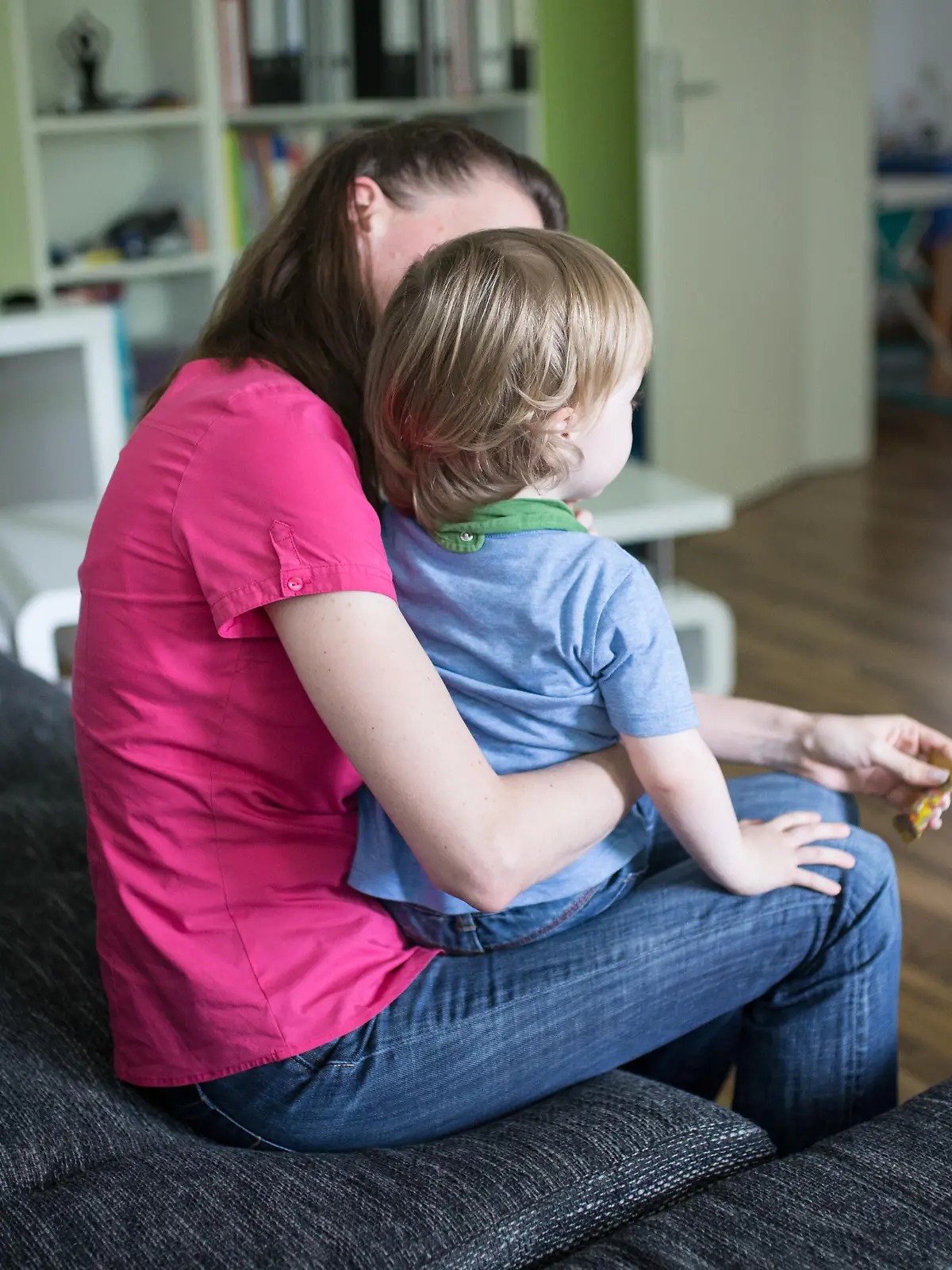 ILLUSTRATION - ARCHIV - 01.07.2016, Nordrhein-Westfalen, Dortmund: Eine Mutter sitzt mit ihrem Sohn auf dem Schoß auf einer Couch. Auch viele Familien leben von Hartz IV. Foto: Marcel Kusch/dpa +++(c) dpa - Nachrichten für Kinder+++