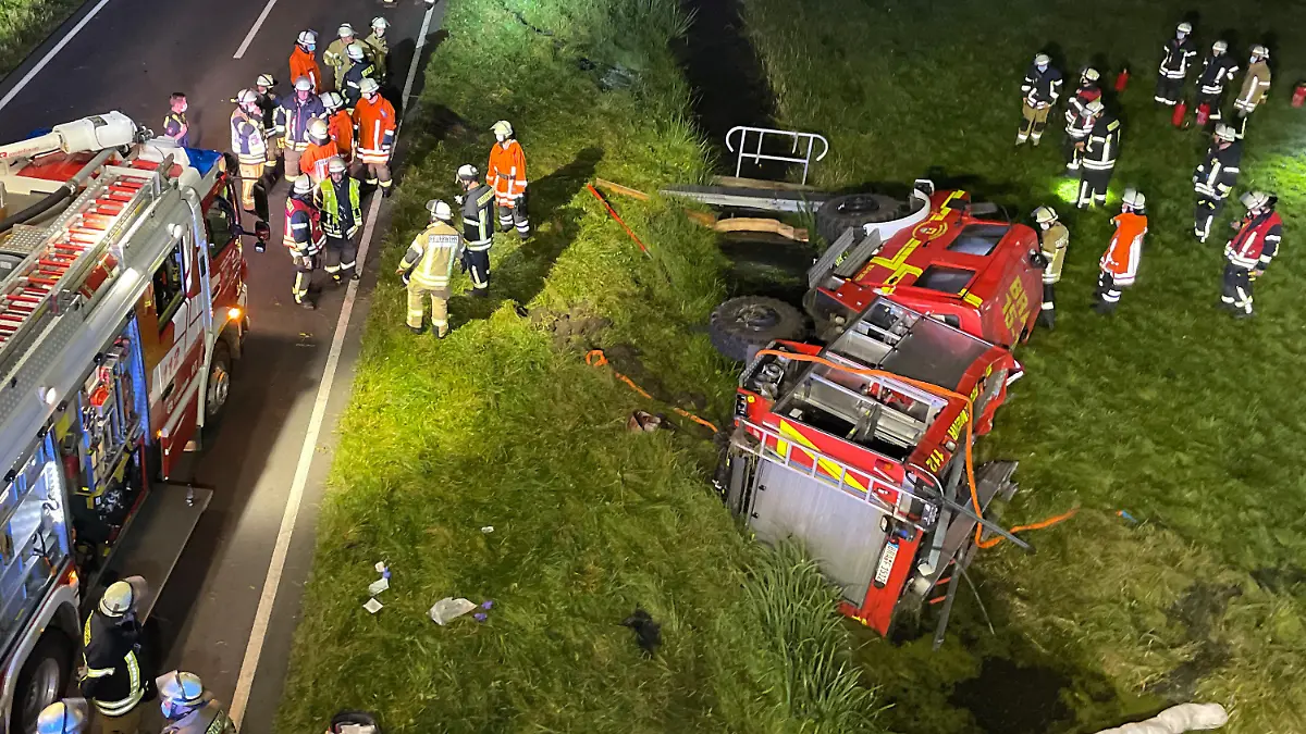 13.09.2021, Niedersachsen, Brake: Feuerwehrleute stehen um ein verunfalltes Einsatzfahrzeug auf der B212 bei Brake (Unterweser). Sechs Feuerwehrleute sind bei einem Unfall mit ihrem Tanklöschfahrzeug kurz vor Brake verletzt worden. Die Feuerwehrleute waren unterwegs zu einer Übung in der Feuerwehrtechnischen Zentrale als mutmaßlich ein Reifen platzte. Foto: Andre van Elten/dpa +++ dpa-Bildfunk +++