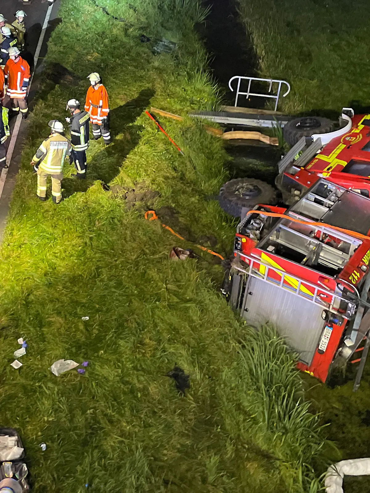 13.09.2021, Niedersachsen, Brake: Feuerwehrleute stehen um ein verunfalltes Einsatzfahrzeug auf der B212 bei Brake (Unterweser). Sechs Feuerwehrleute sind bei einem Unfall mit ihrem Tanklöschfahrzeug kurz vor Brake verletzt worden. Die Feuerwehrleute waren unterwegs zu einer Übung in der Feuerwehrtechnischen Zentrale als mutmaßlich ein Reifen platzte. Foto: Andre van Elten/dpa +++ dpa-Bildfunk +++