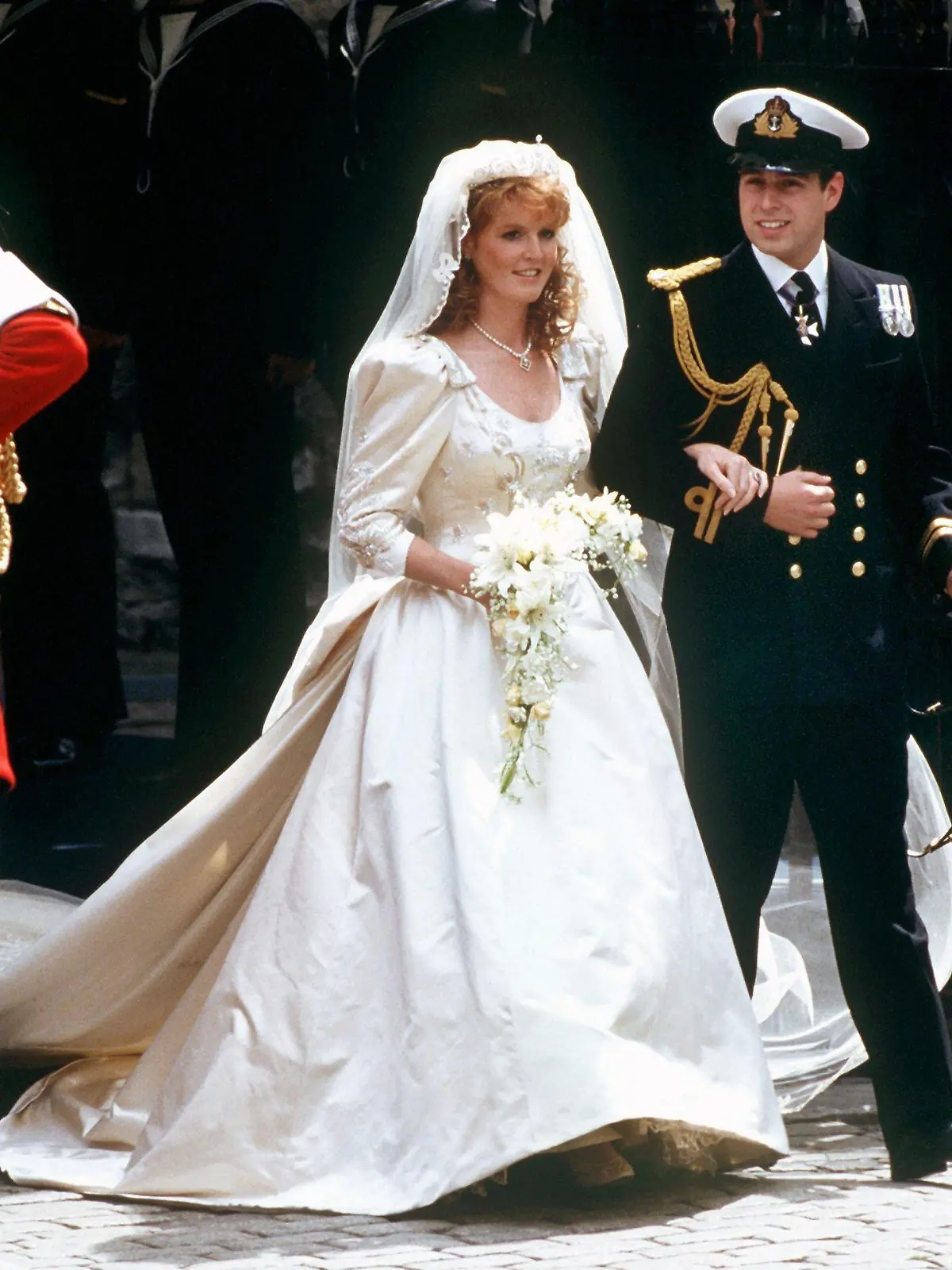 Das glückliche Brautpaar, Prinz Andrew und Sarah Ferguson, nach der prunkvollen Hochzeit am 23. Juli 1986 in London. Die Herzogin von York kann am 15. Oktober 1999 ihren 40. Geburtstag feiern. Sie wurde als Sarah Margaret Ferguson in London geboren. Nach der Grundschule und dem Mädchenpensionat absolvierte sie eine Sekretärinnenausbildung. In diesem Beruf arbeitete sie später auch, bevor sie Prinz Andrew in Ascot kennen und lieben lernte. Am 23.7.1986 läuteten für beide in Westminster Abbey die Hochzeitsglocken. Doch bereits im verflixten siebten Ehejahr lebten beide wieder getrennt - die beiden Töchter blieben bei Fergie. Am 30.5.1996 wurde das Paar offiziell geschieden. Beide pflegen trotz der Trennung ein freundschaftliches Verhältnis.