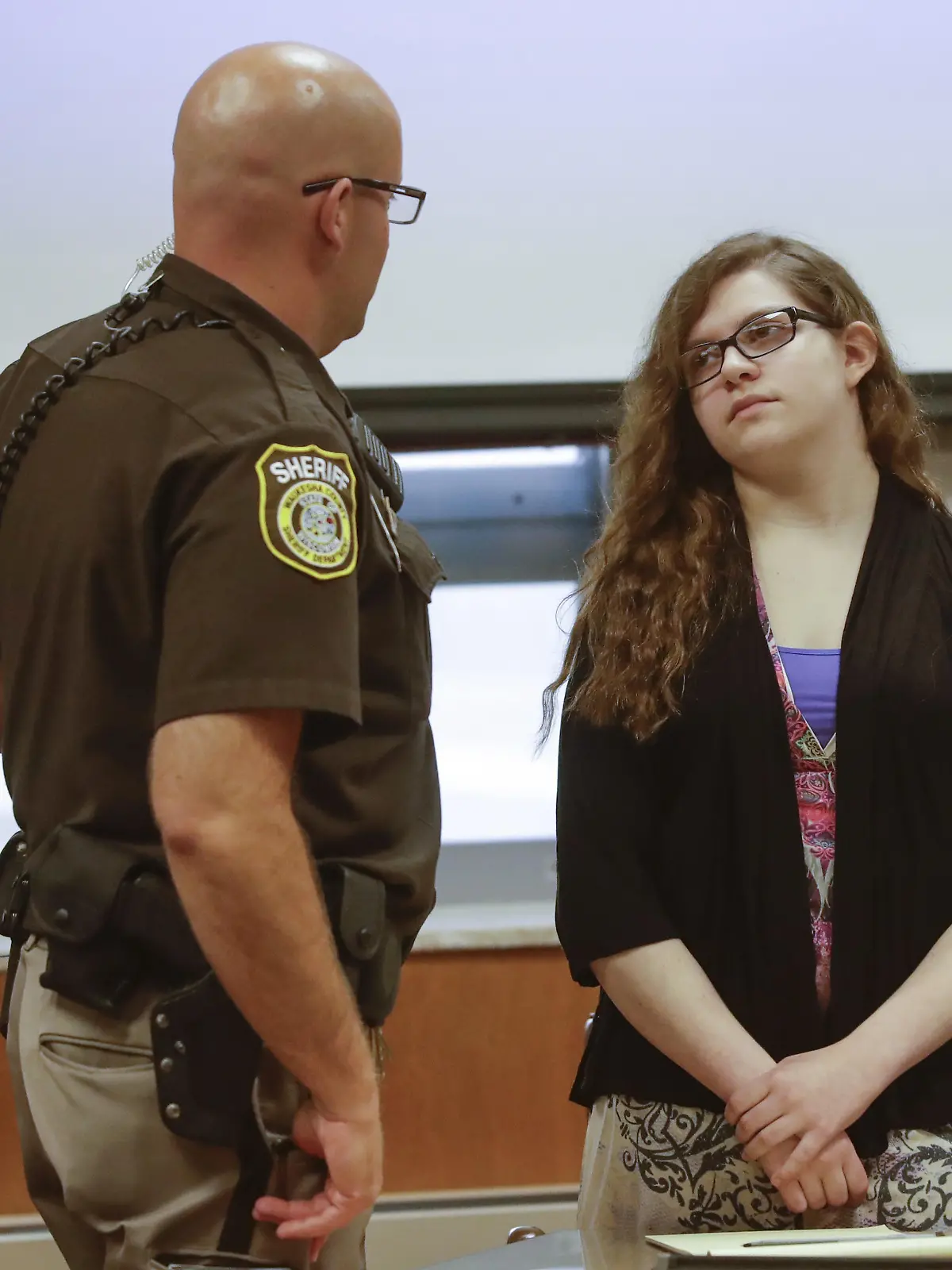 Anissa Weier talks to a sheriff's deputy during a pause in jury selection in the trial to determine 15-year-old Weier's competency at Waukesha County Courthouse Monday, Sept 11, 2017, in Waukesha, Wis. Prosecutors allege that Weier and her friend, Morgan Geyser, lured classmate Payton Leutner into a Waukesha park in May 2014 and stabbed her 19 times. The girls have said it was an effort to please a fictional horror character known as Slender Man.  (AP Photo/Morry Gash, Pool) |