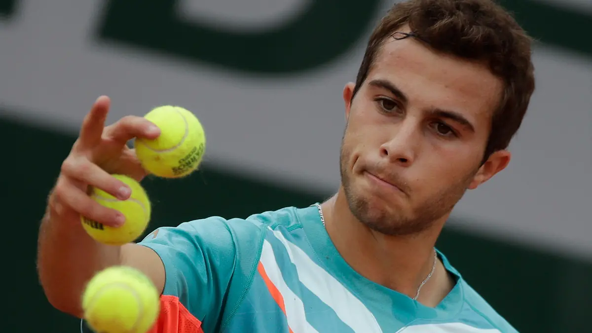 FILE - France's Hugo Gaston prepares to serve against Japan's Yoshihito Nishioka in the second round match of the French Open tennis tournament at the Roland Garros stadium in Paris, France, Wednesday, Sept. 30, 2020. On Monday, May 22, 2023, the ATP Tour announced Gaston was fined 144,000 euros (about $155,000) - more than he’s collected in prize money so far in 2023 - for pulling a ball out of his pocket and throwing it on the court during a point in an attempt to get a do-over, his fourth unsportsmanlike conduct violation this season. (AP Photo/Alessandra Tarantino, File)
