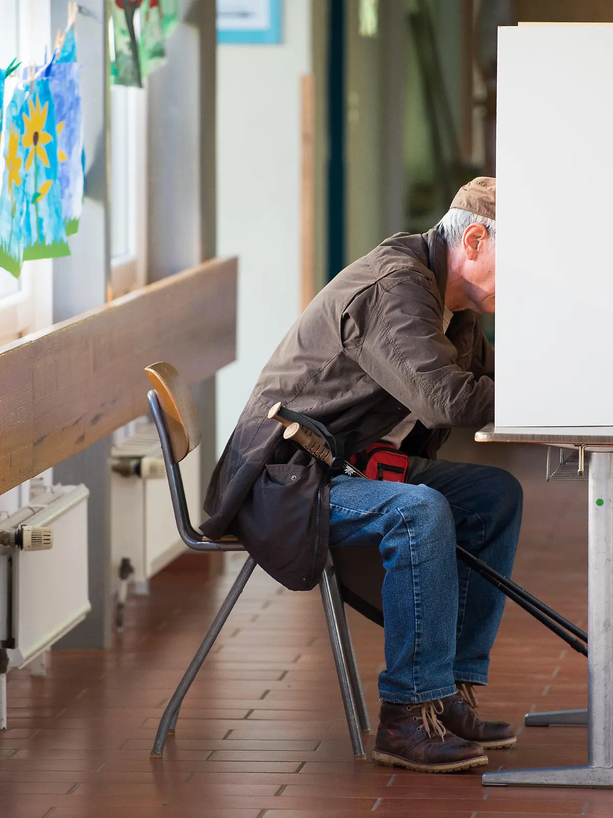 Ein älterer Mann sitzt am 15.10.2017 in Herzberg (Niedersachsen) an einer Wahlkabine bei der Stimmabgabe für die Landtagswahl in Niedersachsen. Foto: Swen Pförtner/dpa +++(c) dpa - Bildfunk+++