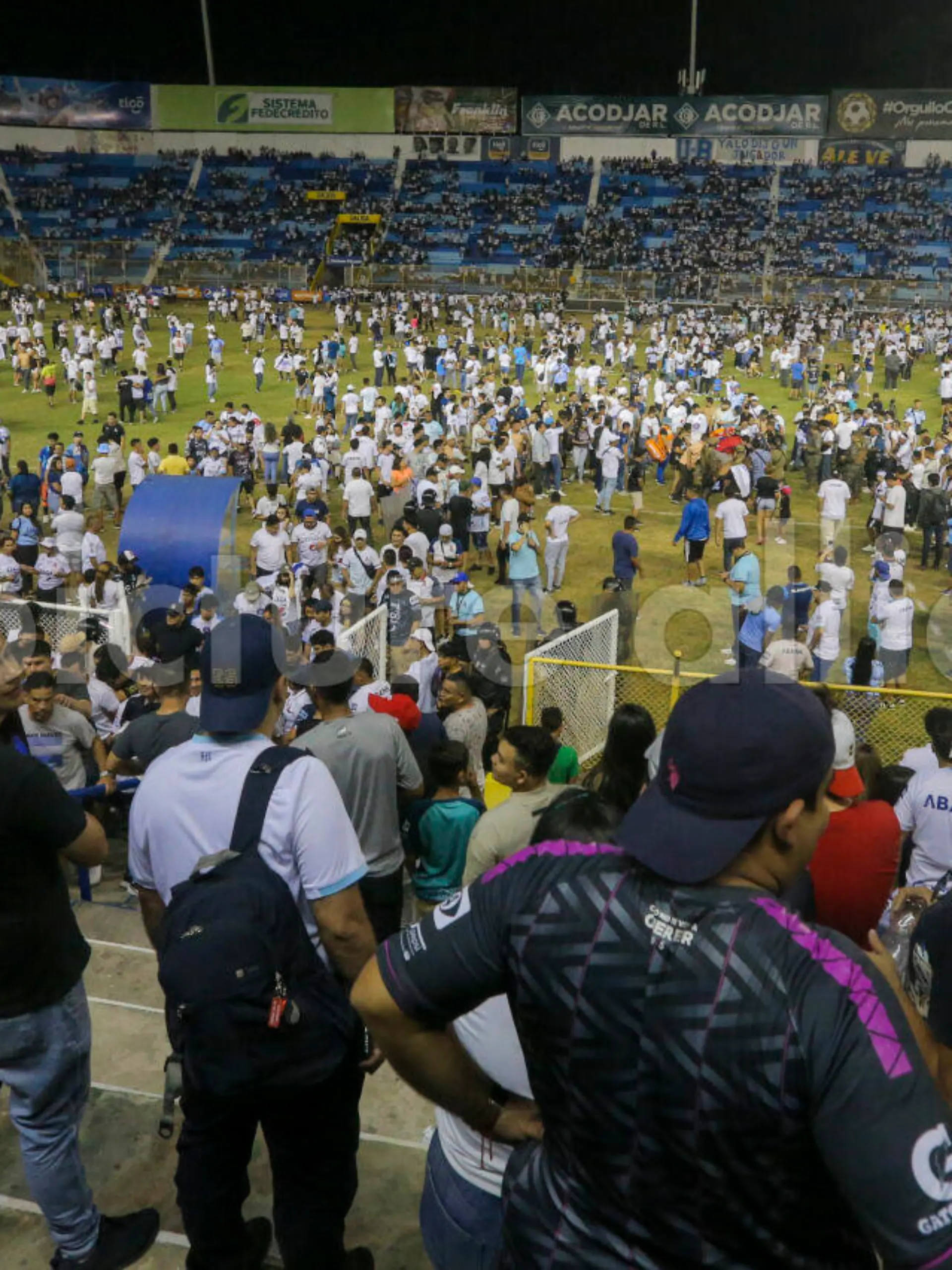 Fans take to the field of Cuscatlan stadium in San Salvador, El Salvador, Saturday, May 20, 2023. At least nine people were killed and dozens more injured when stampeding fans pushed through one of the access gates at a quarterfinal Salvadoran league soccer match between Alianza and FAS. (AP Photo/Milton Flores)