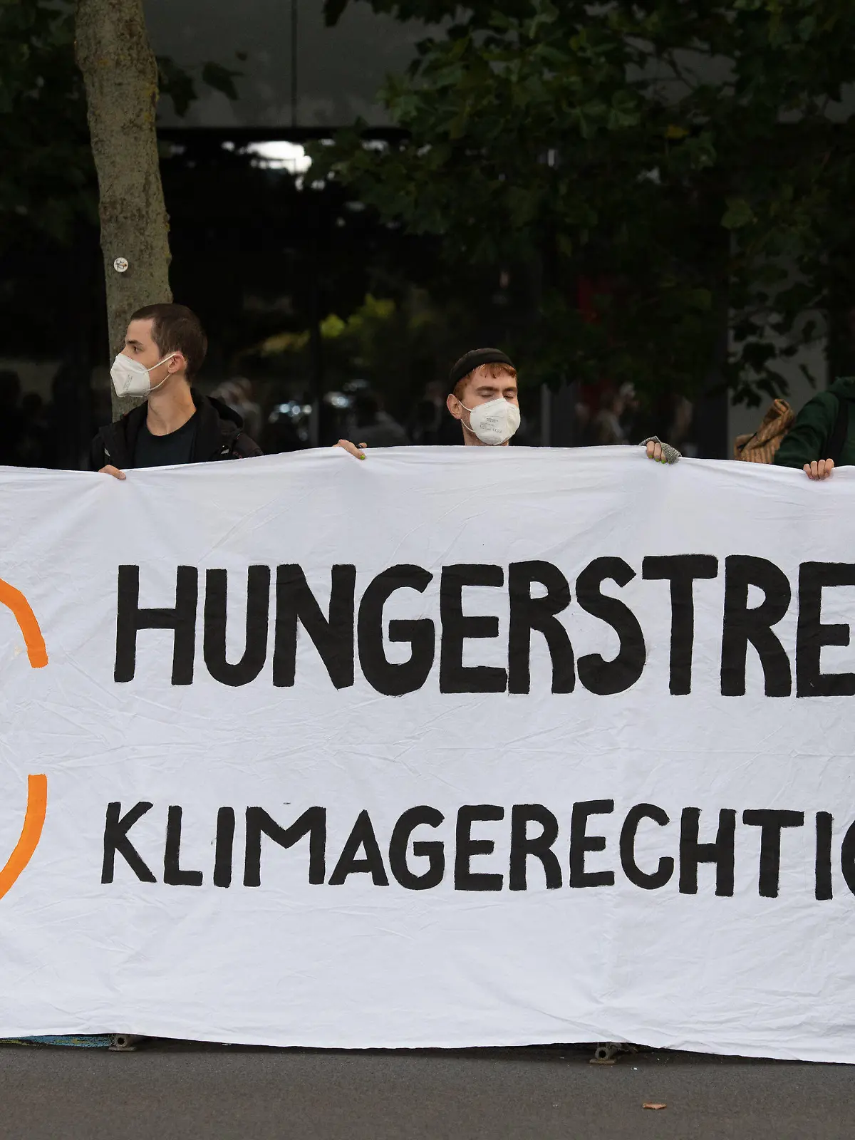 12.09.2021, Berlin: Demonstranten halten vor einem Fernsehstudio in Berlin Adlershof ein Plakat mit der Aufschrift "Hungerstreik für Klimagerechtigkeit". Die Kanzlerkandidaten von Bündnis 90/Die Grünen, CDU und SPD, Baerbock, Laschet und Scholz treffen in einer TV Diskussion bei ARD und ZDF aufeinander. Foto: Christophe Gateau/dpa +++ dpa-Bildfunk +++