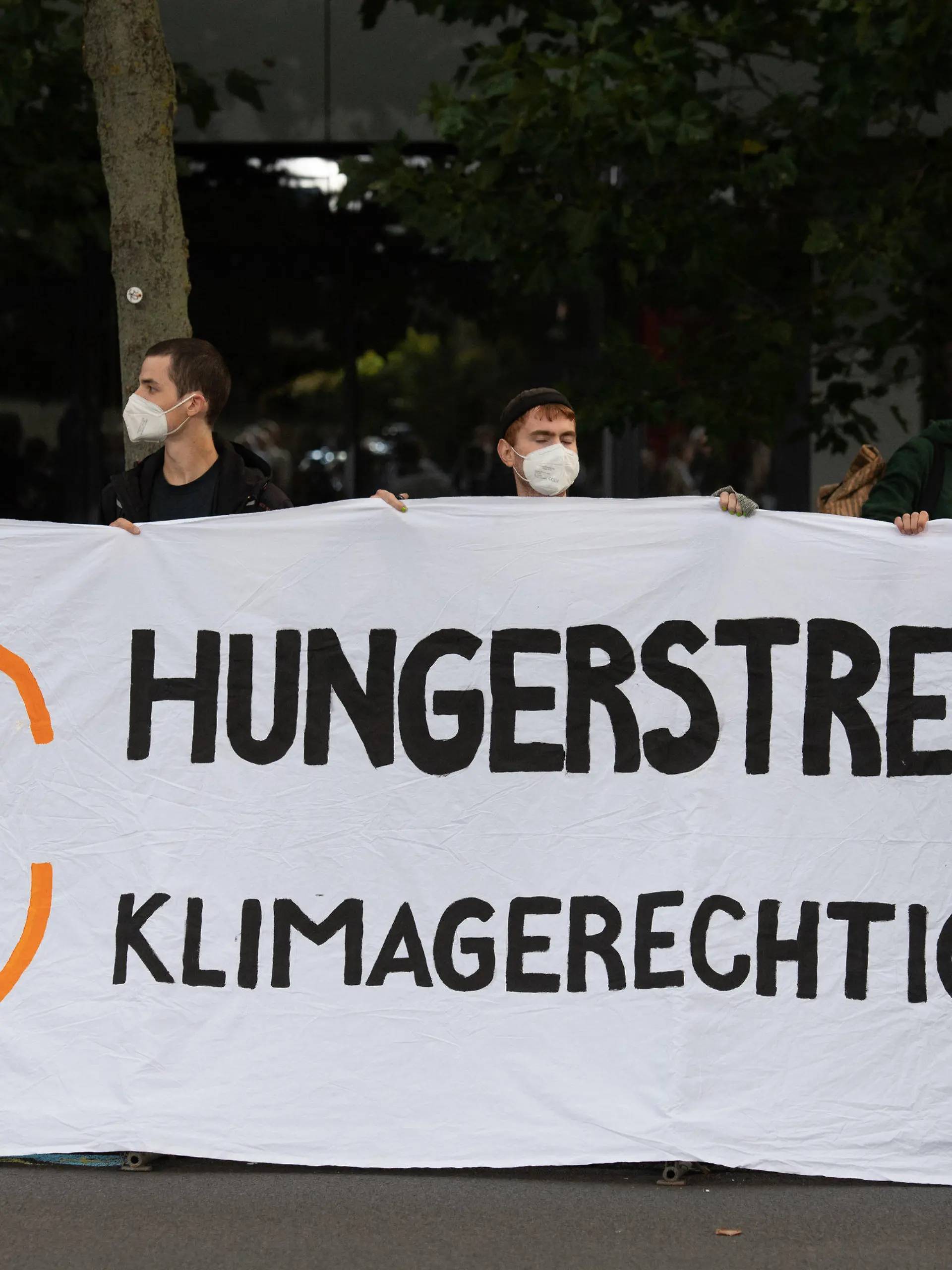 12.09.2021, Berlin: Demonstranten halten vor einem Fernsehstudio in Berlin Adlershof ein Plakat mit der Aufschrift "Hungerstreik für Klimagerechtigkeit". Die Kanzlerkandidaten von Bündnis 90/Die Grünen, CDU und SPD, Baerbock, Laschet und Scholz treffen in einer TV Diskussion bei ARD und ZDF aufeinander. Foto: Christophe Gateau/dpa +++ dpa-Bildfunk +++