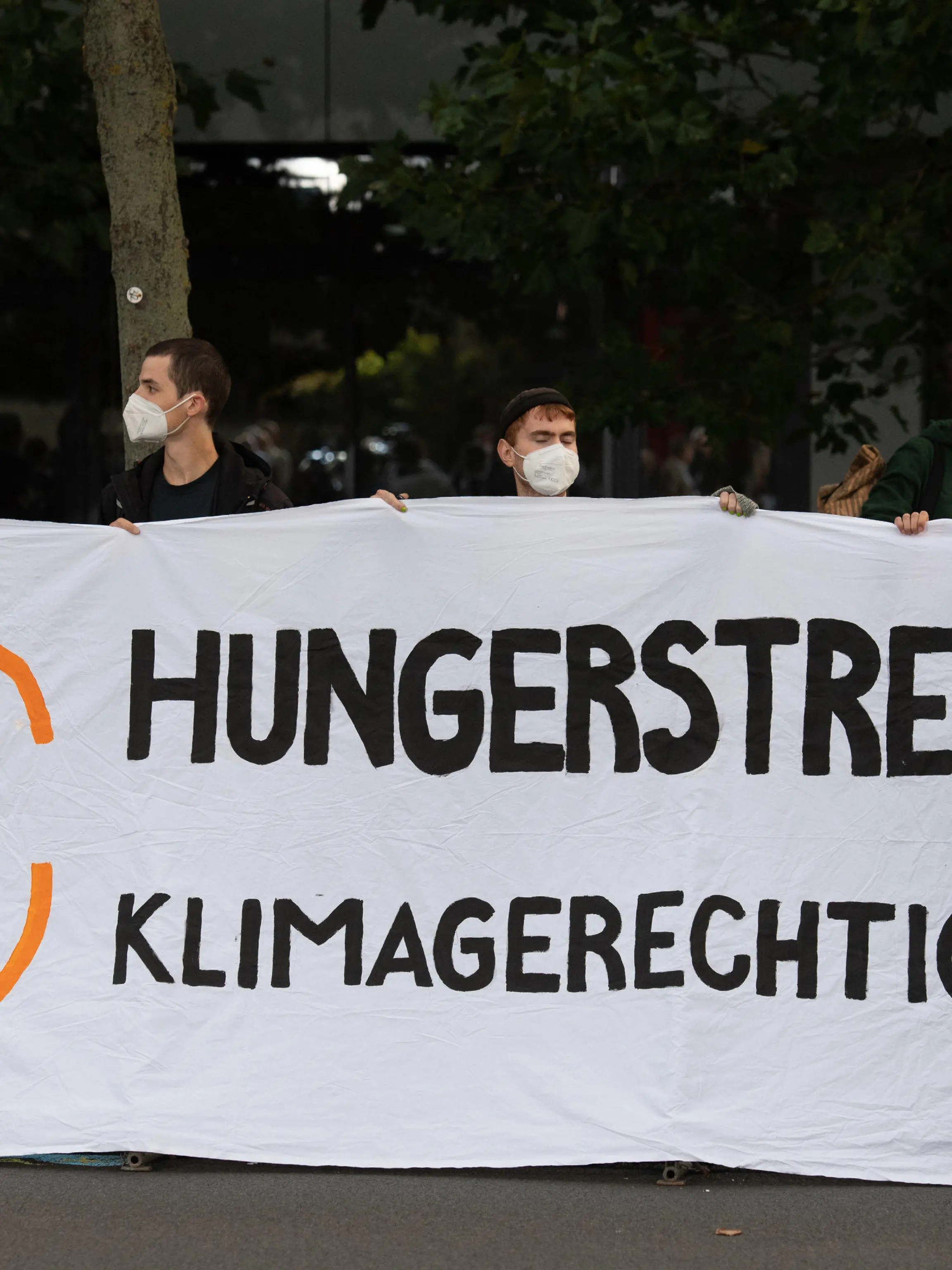 12.09.2021, Berlin: Demonstranten halten vor einem Fernsehstudio in Berlin Adlershof ein Plakat mit der Aufschrift "Hungerstreik für Klimagerechtigkeit". Die Kanzlerkandidaten von Bündnis 90/Die Grünen, CDU und SPD, Baerbock, Laschet und Scholz treffen in einer TV Diskussion bei ARD und ZDF aufeinander. Foto: Christophe Gateau/dpa +++ dpa-Bildfunk +++