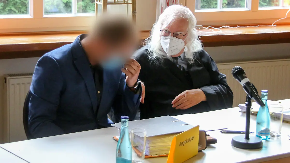 16.08.2021, Emden: Der Angeklagte (l) sitzt kurz vor dem Prozess-Auftakt der Gerichtsverhandlung neben seinem Rechtsanwalt Reinhard Nollmann. Rund fünf Jahre nach einem schweren Bootsunfall mit zwei Toten bei Barßel (Kreis Cloppenburg) steht der 30 Jahre alte Mann vor Gericht. Die Staatsanwaltschaft wirft dem Bootsfahrer fahrlässige Tötung, gefährliche Körperverletzung und Trunkenheit vor. (zu dpa: "Bootsunfall von Barßel mit zwei Toten wird erneut verhandelt") Foto: Lennart Stock/dpa - ACHTUNG: Person(en) wurde(n) aus rechtlichen Gründen gepixelt +++ dpa-Bildfunk +++