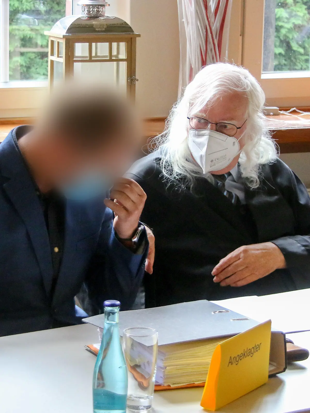 16.08.2021, Emden: Der Angeklagte (l) sitzt kurz vor dem Prozess-Auftakt der Gerichtsverhandlung neben seinem Rechtsanwalt Reinhard Nollmann. Rund fünf Jahre nach einem schweren Bootsunfall mit zwei Toten bei Barßel (Kreis Cloppenburg) steht der 30 Jahre alte Mann vor Gericht. Die Staatsanwaltschaft wirft dem Bootsfahrer fahrlässige Tötung, gefährliche Körperverletzung und Trunkenheit vor. (zu dpa: "Bootsunfall von Barßel mit zwei Toten wird erneut verhandelt") Foto: Lennart Stock/dpa - ACHTUNG: Person(en) wurde(n) aus rechtlichen Gründen gepixelt +++ dpa-Bildfunk +++