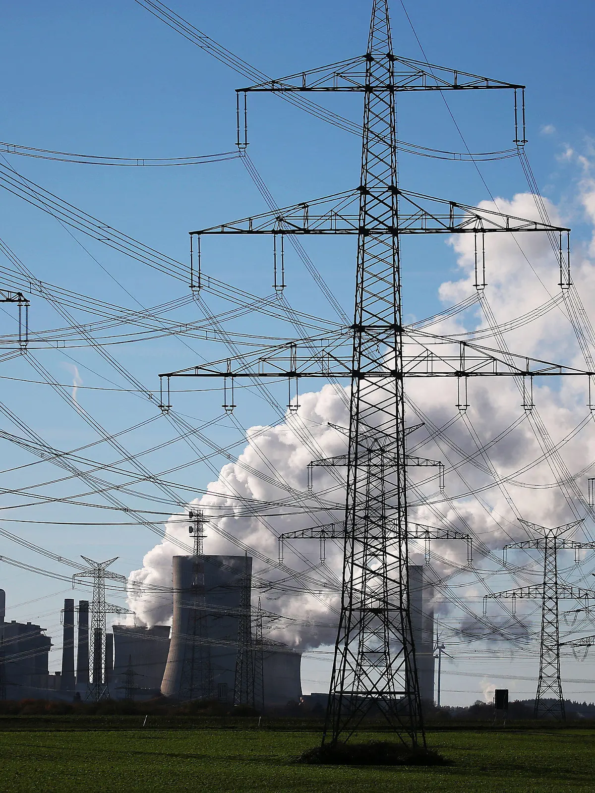 ARCHIV - 18.11.2020, Nordrhein-Westfalen, Bergheim: Dampf steigt aus dem Braunkohlekraftwerk Niederaußem des Energieversorgungskonzerns RWE bei Bergheim hinter Strommasten. (zu dpa "Kohle löst Windkraft als wichtigste Quelle für Stromerzeugung ab") Foto: Oliver Berg/dpa +++ dpa-Bildfunk +++