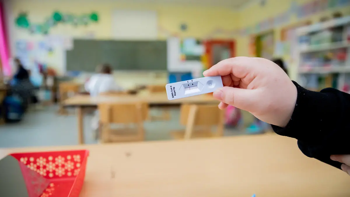 14.04.2021, Berlin: Ein Schüler hält bei einem Probelauf mit Corona-Schnelltests an der Grundschule in der Köllnischen Heide in Berlin-Neukölln seinen negativen Test in die Kamera. Foto: Christoph Soeder/dpa +++ dpa-Bildfunk +++