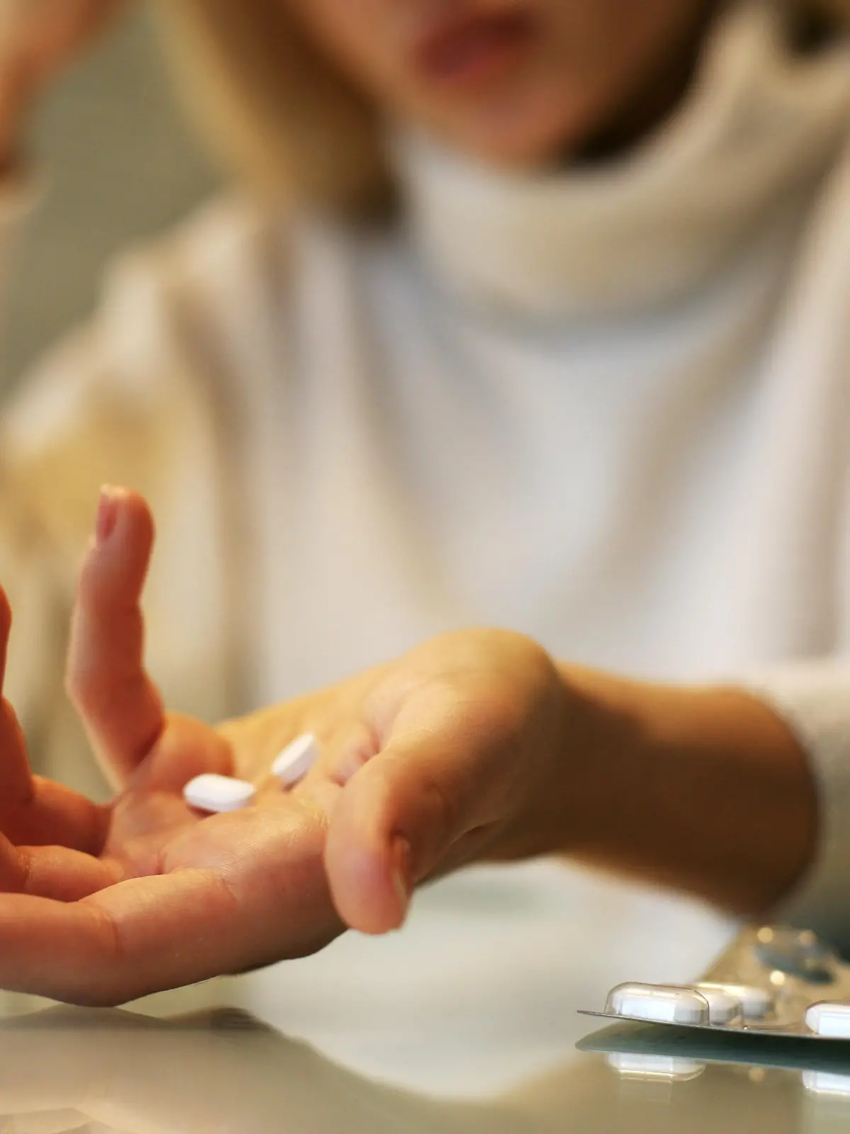 Close up of woman hands holding a pills.