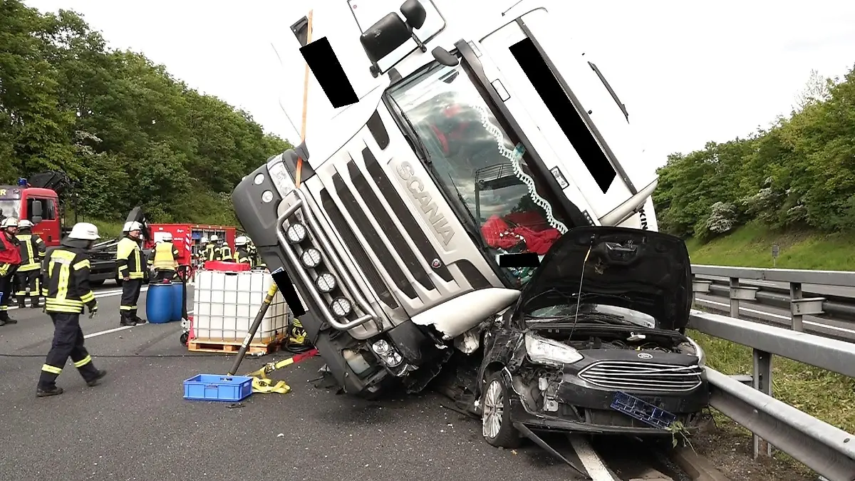 19.05.2023, Niedersachsen, Weyhe: Ein Lkw liegt am Unfallort auf einem Pkw. Auf der A1 zwischen Oyten im Landkreis Verden und dem Bremer Kreuz ist ein Lkw auf ein Auto gekippt. Dabei seien drei Erwachsene schwer und ein Kleinkind leicht verletzt worden, teilte die Autobahnpolizei am Samstagabend mit. Die A1 in Richtung Osnabrück bleibe aufgrund der Bergungsarbeiten noch bis zum frühen Sonntagmorgen gesperrt. Foto: Kai Moorschlatt/Nord-West-Media TV/dpa +++ dpa-Bildfunk +++