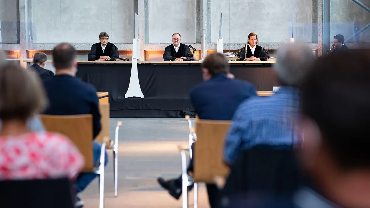 14.09.2021, Nordrhein-Westfalen, Hamm: Der Vorsitzende Richter Johannes Wieseler (M) und seine Kollegen Volker Messing (l) und Dirk Pelzer sitzen zu Beginn der Berufungsverhandlung zu den Schadensersatzforderungen der Hinterbliebenen des Germanwings-Absturzes 2015 in der Lobby des Oberlandesgerichtes. Die Angehörigen fordern von der Lufthansa AG und deren Flugschule in den USA zusätzliche Zahlungen neben den bereits geleisteten. Auf Grund von Cornabstimmungen fand die Verhandlung in der Lobby des OLG statt. Foto: Guido Kirchner/dpa +++ dpa-Bildfunk +++