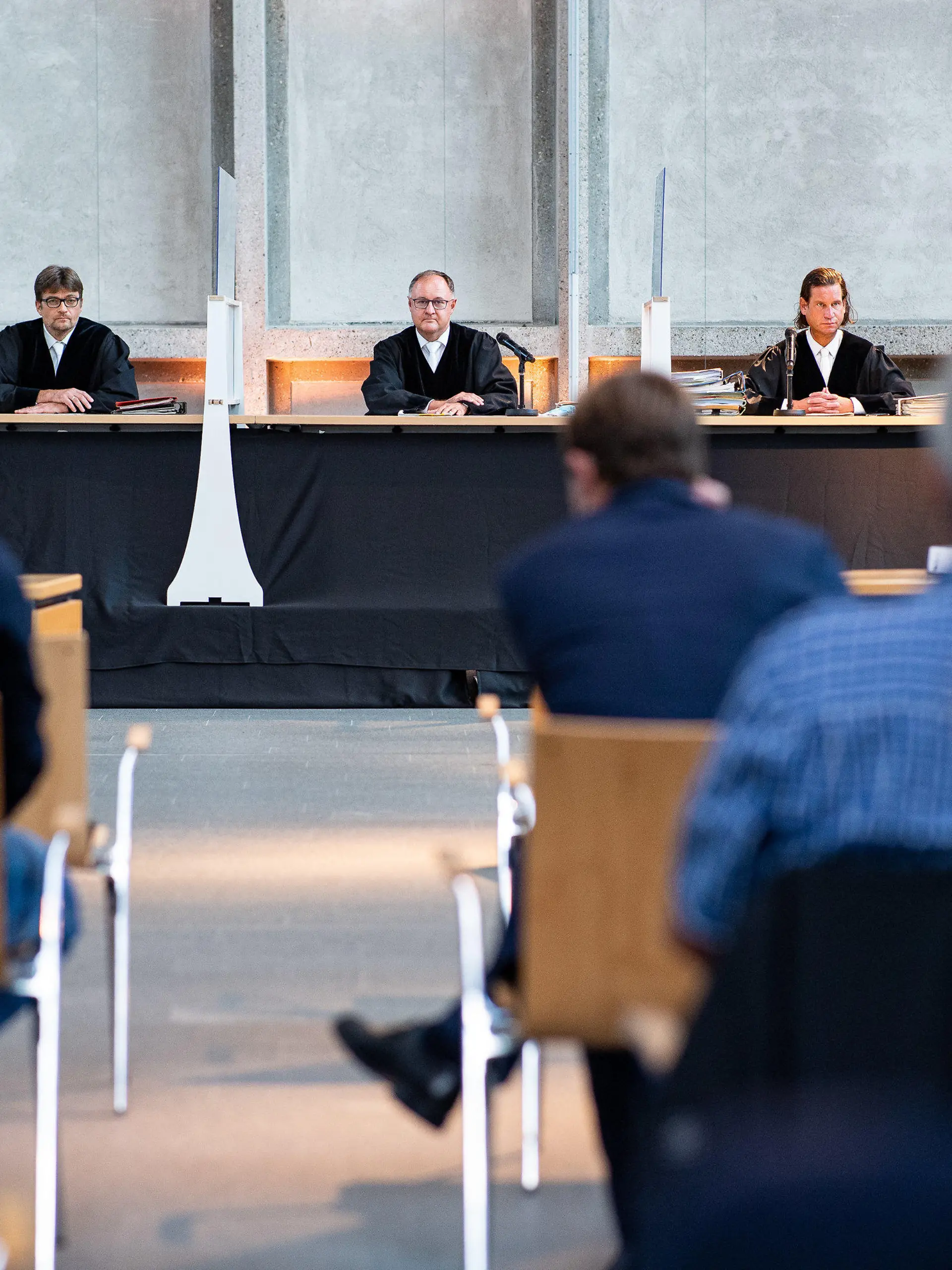 14.09.2021, Nordrhein-Westfalen, Hamm: Der Vorsitzende Richter Johannes Wieseler (M) und seine Kollegen Volker Messing (l) und Dirk Pelzer sitzen zu Beginn der Berufungsverhandlung zu den Schadensersatzforderungen der Hinterbliebenen des Germanwings-Absturzes 2015 in der Lobby des Oberlandesgerichtes. Die Angehörigen fordern von der Lufthansa AG und deren Flugschule in den USA zusätzliche Zahlungen neben den bereits geleisteten. Auf Grund von Cornabstimmungen fand die Verhandlung in der Lobby des OLG statt. Foto: Guido Kirchner/dpa +++ dpa-Bildfunk +++