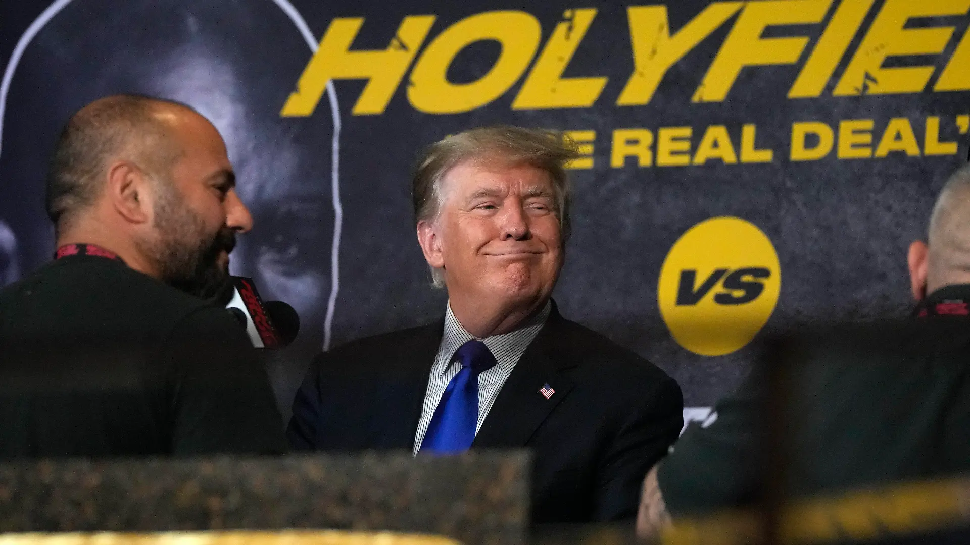 11.09.2021, USA, Hollywood: Der ehemalige US-Präsident Donald Trump (M) lächelt für ein Foto mit Anhängern, während er und sein Sohn Donald Trump Jr. (l) sich darauf vorbereiten, eine Boxveranstaltung zu kommentieren, die von einem Kampf zwischen dem ehemaligen Schwergewichtschampion Evander Holyfield und dem ehemaligen MMA-Star Vitor Belfort angeführt wird. Foto: Rebecca Blackwell/AP/dpa +++ dpa-Bildfunk +++