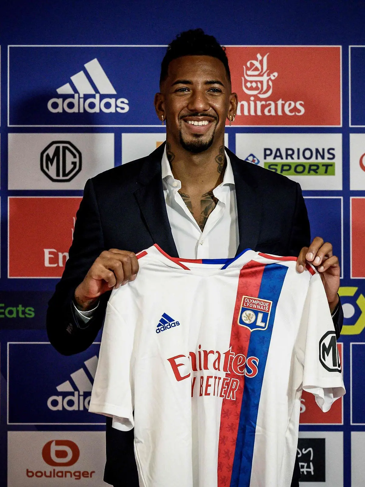 ARCHIV - 01.09.2021, Lyon: Fußball: Jerome Boateng, deutscher Fußballspieler, steht mit seinem Trikot nach seiner offiziellen Vorstellung im Groupama-Stadion. Der frühere deutsche Fußball-Nationalspieler Jerome Boateng spielt zukünftig bei Olympique Lyon. Kurz vor seinem 33. Geburtstag unterschrieb der Weltmeister von 2014 bei dem französischen Erstligisten einen Zweijahresvertrag. (Zu dpa "Jerome Boateng vor möglichem Debüt für Lyon") Foto: Jeff Pachoud/AFP/dpa +++ dpa-Bildfunk +++