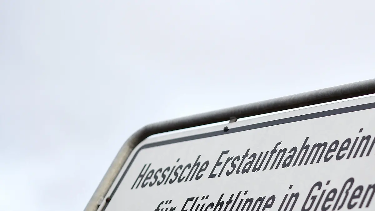 ARCHIV - Ein Schild mit der Aufschrift "Hessische Erstaufnahmeeinrichtung für Flüchtlinge in Gießen" weist am 17.11.2015 an einer Straßenkreuzung zur Einrichtung in Gießen (Hessen) hin. (zu dpa «Bundeswehrsoldat soll als Flüchtling getarnt Anschlag geplant haben» vom 27.04.2017) Foto: Arne Dedert/dpa +++(c) dpa - Bildfunk+++