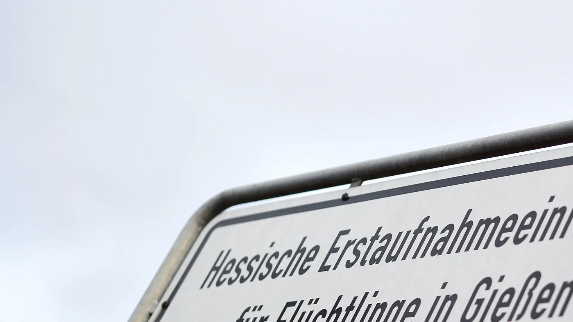 ARCHIV - Ein Schild mit der Aufschrift "Hessische Erstaufnahmeeinrichtung für Flüchtlinge in Gießen" weist am 17.11.2015 an einer Straßenkreuzung zur Einrichtung in Gießen (Hessen) hin. (zu dpa «Bundeswehrsoldat soll als Flüchtling getarnt Anschlag geplant haben» vom 27.04.2017) Foto: Arne Dedert/dpa +++(c) dpa - Bildfunk+++