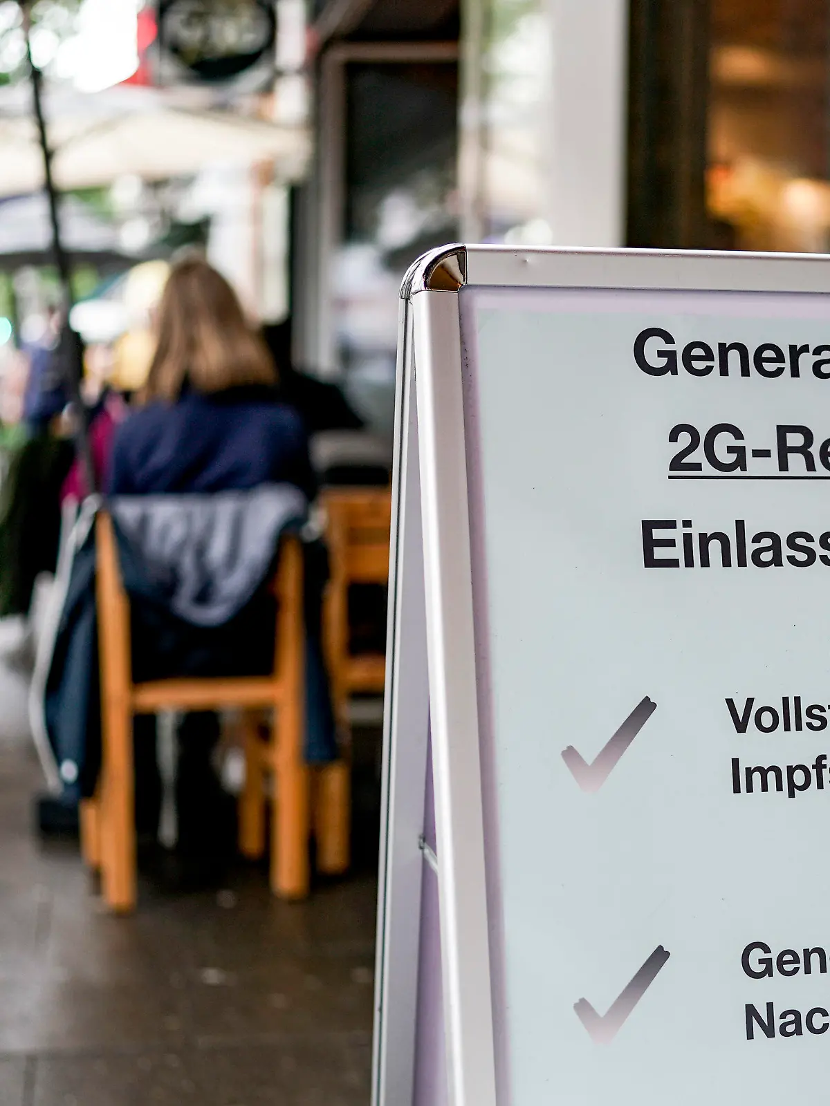 28.08.2021, Hamburg: Vor einer Bar im Hamburger Stadtteil St. Georg steht ein Hinweisschild, welches auf den Einlass nach der 2GRegel hinweist. Die in Hamburg eingeführte 2G-Regel besagt, dass nur noch Geimpfte und Genesene die jeweiligen Betriebe betreten dürfen. Foto: Axel Heimken/dpa +++ dpa-Bildfunk +++