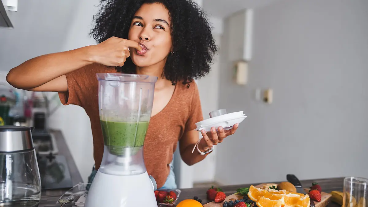 Shot of a young woman making a healthy smoothie at home