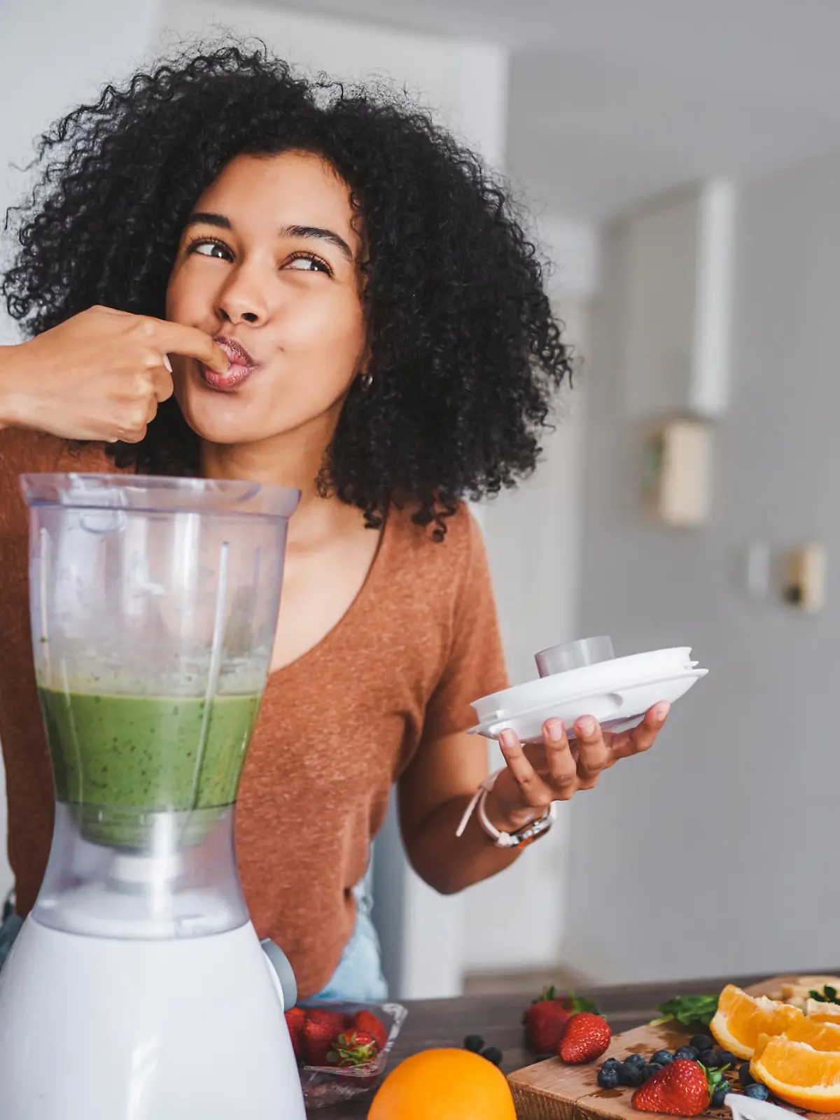 Shot of a young woman making a healthy smoothie at home