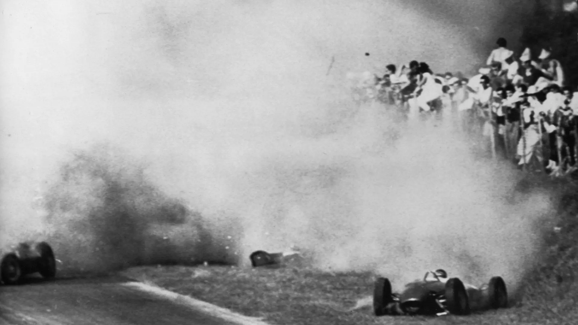 ARCHIV - Dichter Qualm liegt nach der Kollisions-Tragödie vom 10.09.1961 über der Unglückstätte von Monza. Links der Ferrari des deutschen Formel 1-Fahrers Wolfgang Graf Berghe von Trips, der kurz nach dem Start zum Großen Preis von Italien bei der Doppelkollision erst mit dem Engländer Jim Clark und dann mit dessen Landsmann Ashmore den Tod findet. Rechts der Wagen Clarks, durch den 15 Zuschauer in den Tod gerissen werden. (zu dpa-KORR: "Von Trips' Horrorcrash in Monza: Tod statt Titel" vom 06.09.2011)  +++(c) dpa - Bildfunk+++