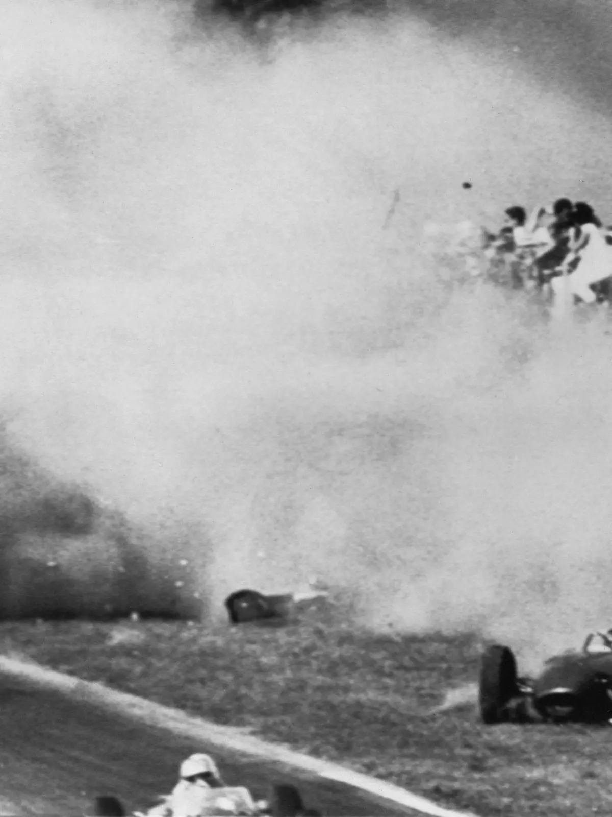 ARCHIV - Dichter Qualm liegt nach der Kollisions-Tragödie vom 10.09.1961 über der Unglückstätte von Monza. Links der Ferrari des deutschen Formel 1-Fahrers Wolfgang Graf Berghe von Trips, der kurz nach dem Start zum Großen Preis von Italien bei der Doppelkollision erst mit dem Engländer Jim Clark und dann mit dessen Landsmann Ashmore den Tod findet. Rechts der Wagen Clarks, durch den 15 Zuschauer in den Tod gerissen werden. (zu dpa-KORR: "Von Trips' Horrorcrash in Monza: Tod statt Titel" vom 06.09.2011)  +++(c) dpa - Bildfunk+++