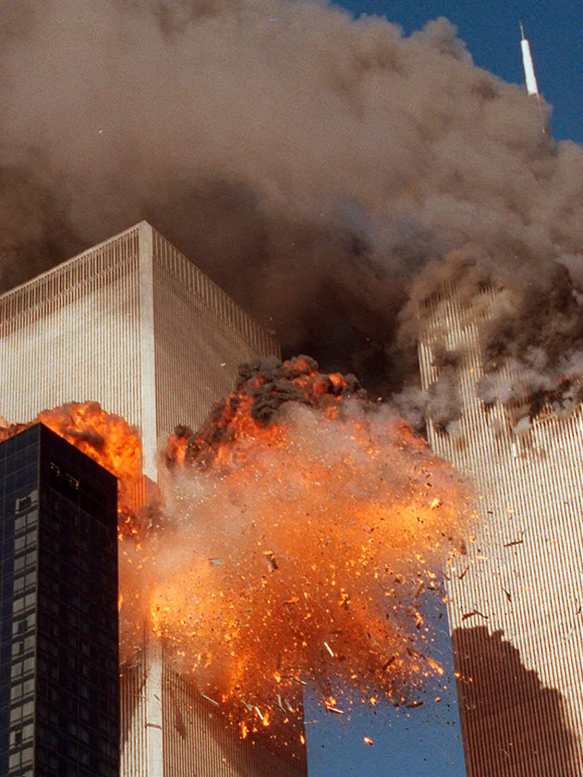 FILE - In this Sept. 11, 2001, file photo, smoke billows from one of the towers of the World Trade Center and flames as debris explodes from the second tower in New York. Relatives of the victims of the Sept. 11 attacks called Thursday, Sept. 2, for the Justice Department's inspector general to investigate the FBI's failure to produce certain pieces of evidence from its investigation. (AP Photo/Chao Soi Cheong, File)