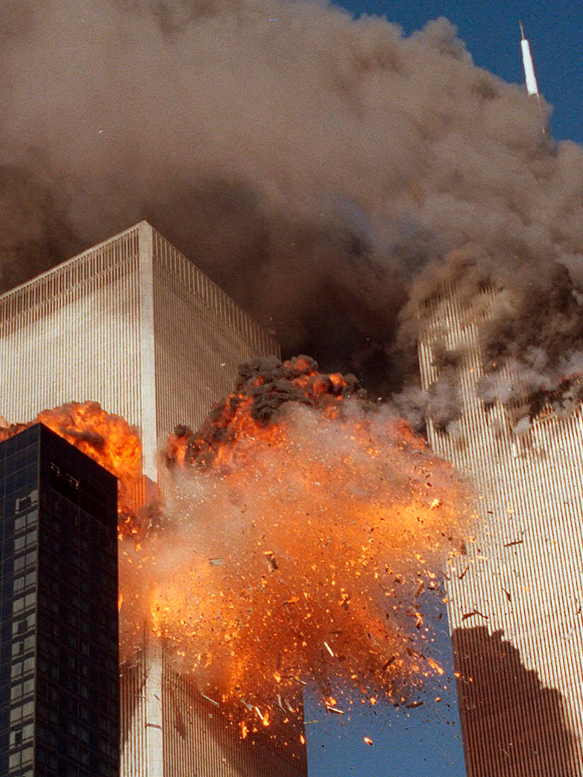 FILE - In this Sept. 11, 2001, file photo, smoke billows from one of the towers of the World Trade Center and flames as debris explodes from the second tower in New York. Relatives of the victims of the Sept. 11 attacks called Thursday, Sept. 2, for the Justice Department's inspector general to investigate the FBI's failure to produce certain pieces of evidence from its investigation. (AP Photo/Chao Soi Cheong, File)